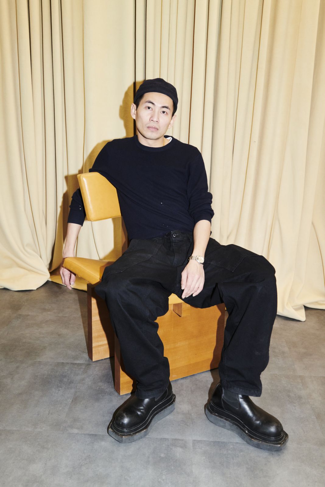 Self-Portrait founder Han Chong sitting on orange chair