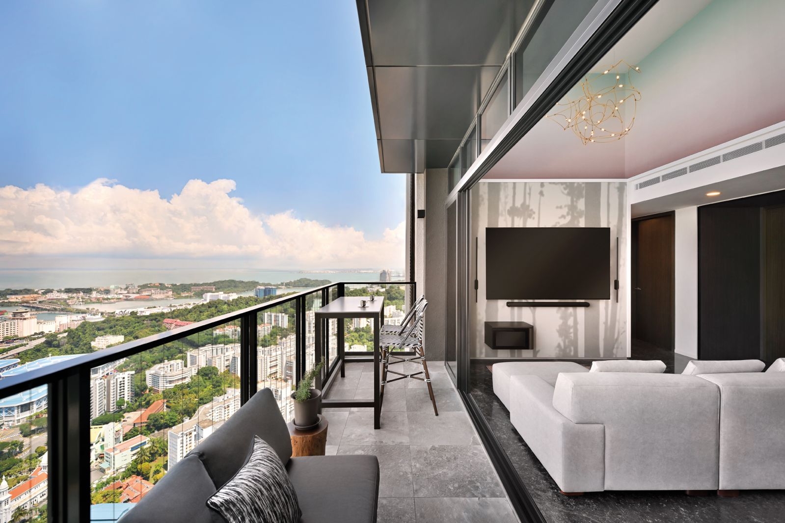 The living room seamlessly opens out to the balcony, which also features a stylish bar-height seating corner