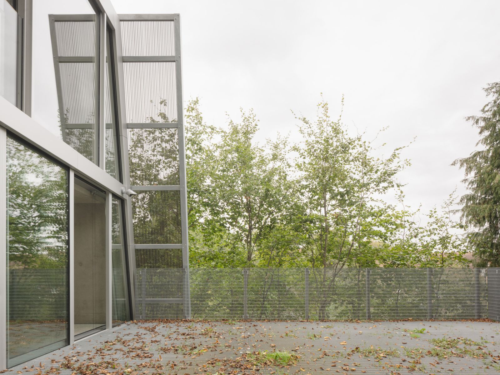 The home is framed by tall, mature trees that lend it privacy and natural shade