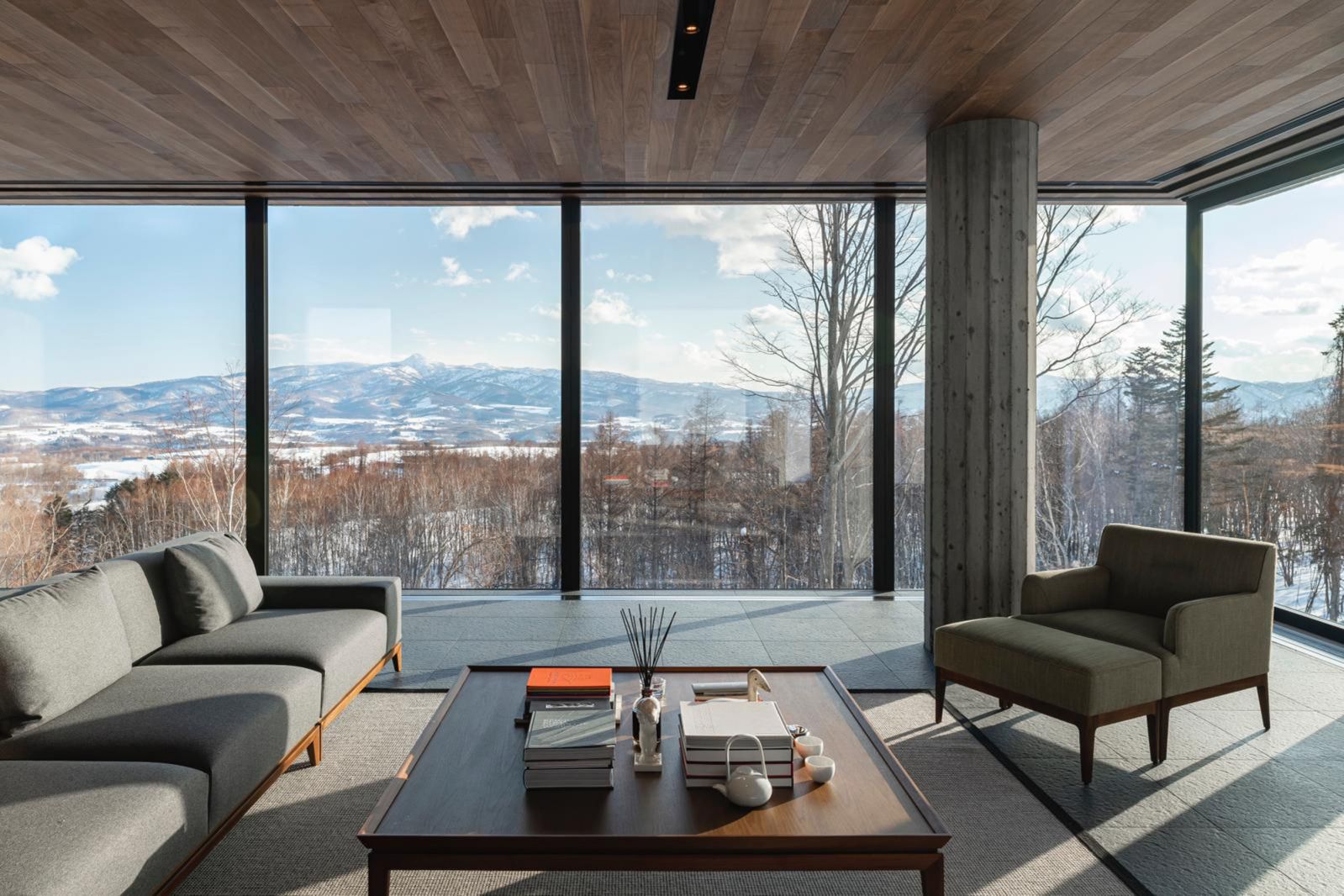 Full-height windows open up the living area to expansive views of the wintry landscape