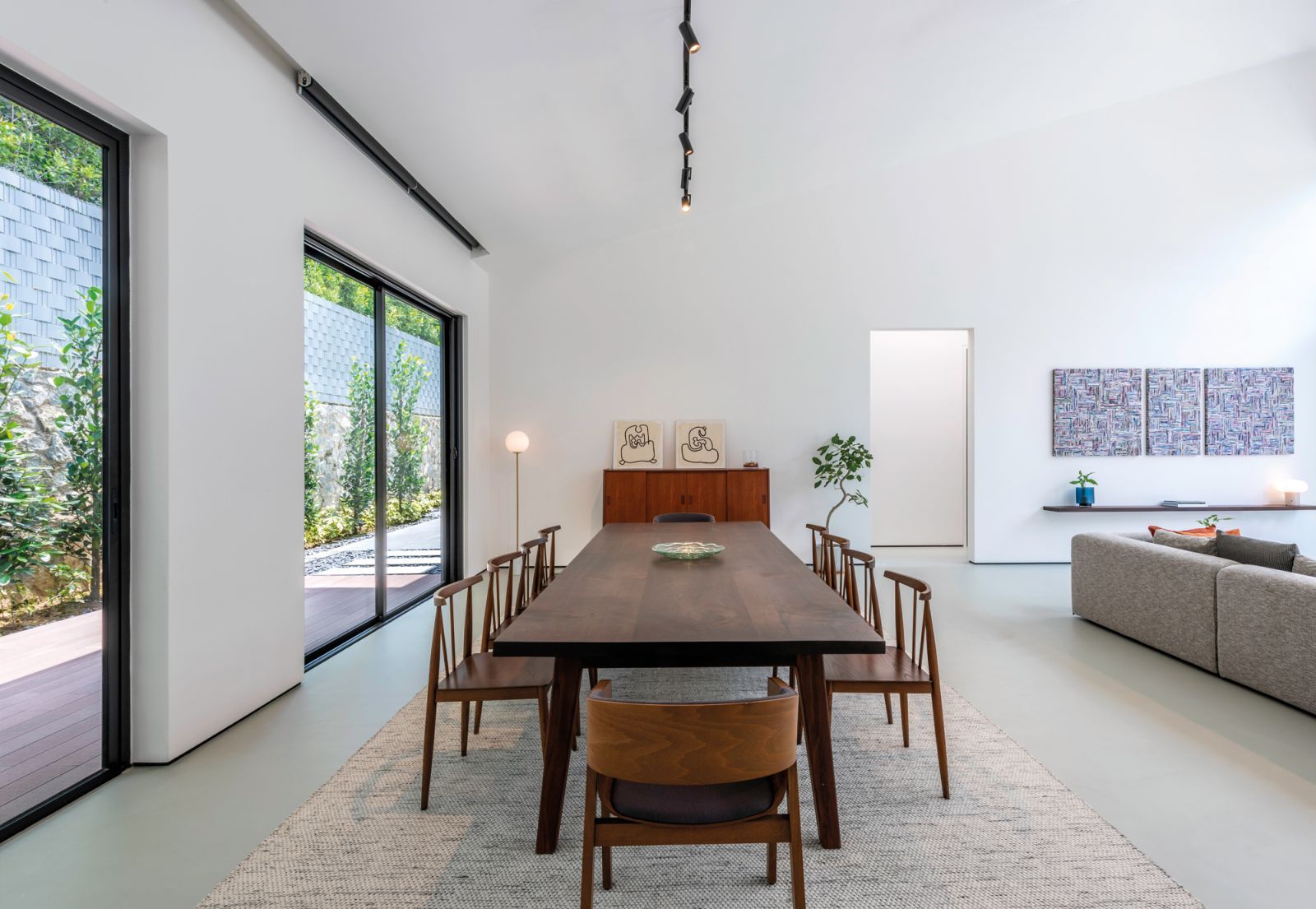A timber dining table and chairs imbue the neutral palette with earthiness and warmth