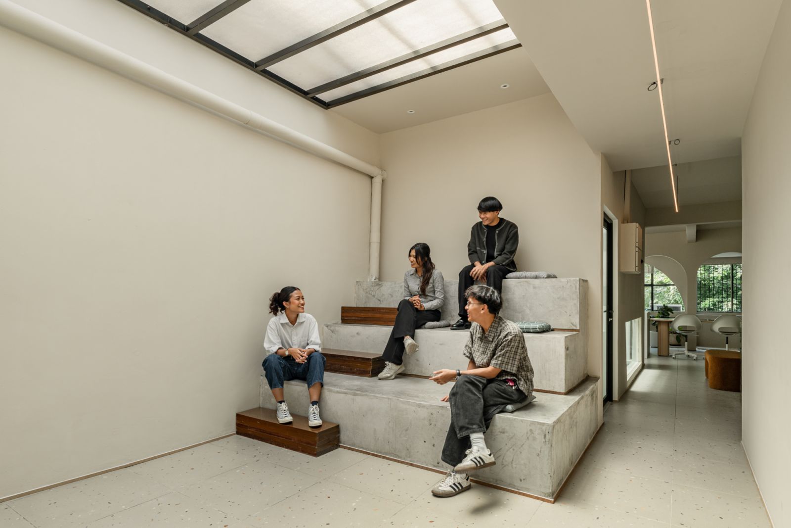 The studio’s amphitheater-style seating area beneath a skylight functions as an informal gathering spot
