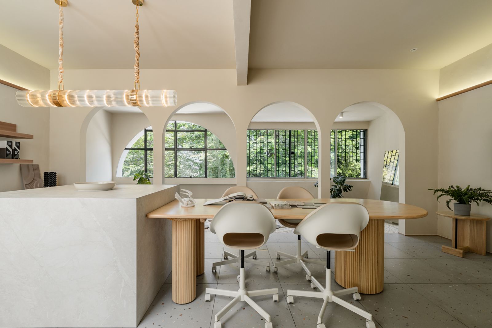The space includes a round meeting table with modern swivel chairs