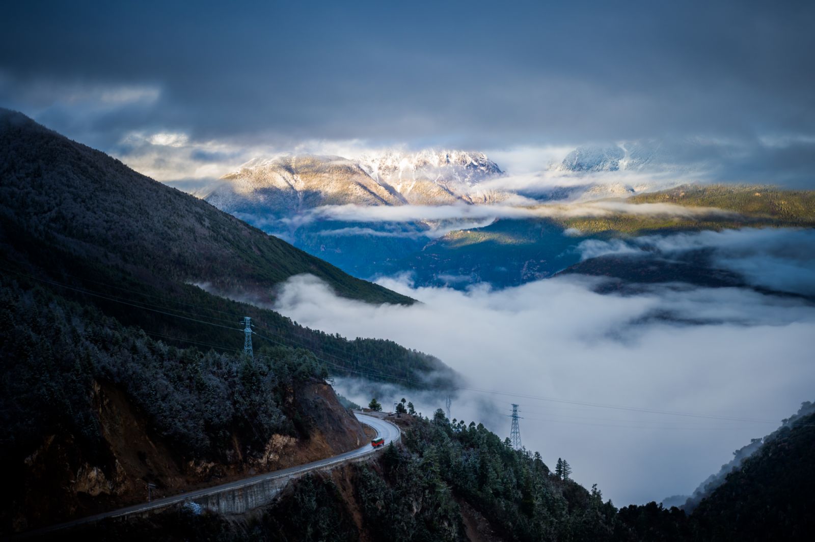 A bus is running on the way up in the cloud in Deqin in Yunnan province, China. The well-known beautiful Meili snow mountain is hiding in the cloud. You do need some luck to see Meili's ture face.