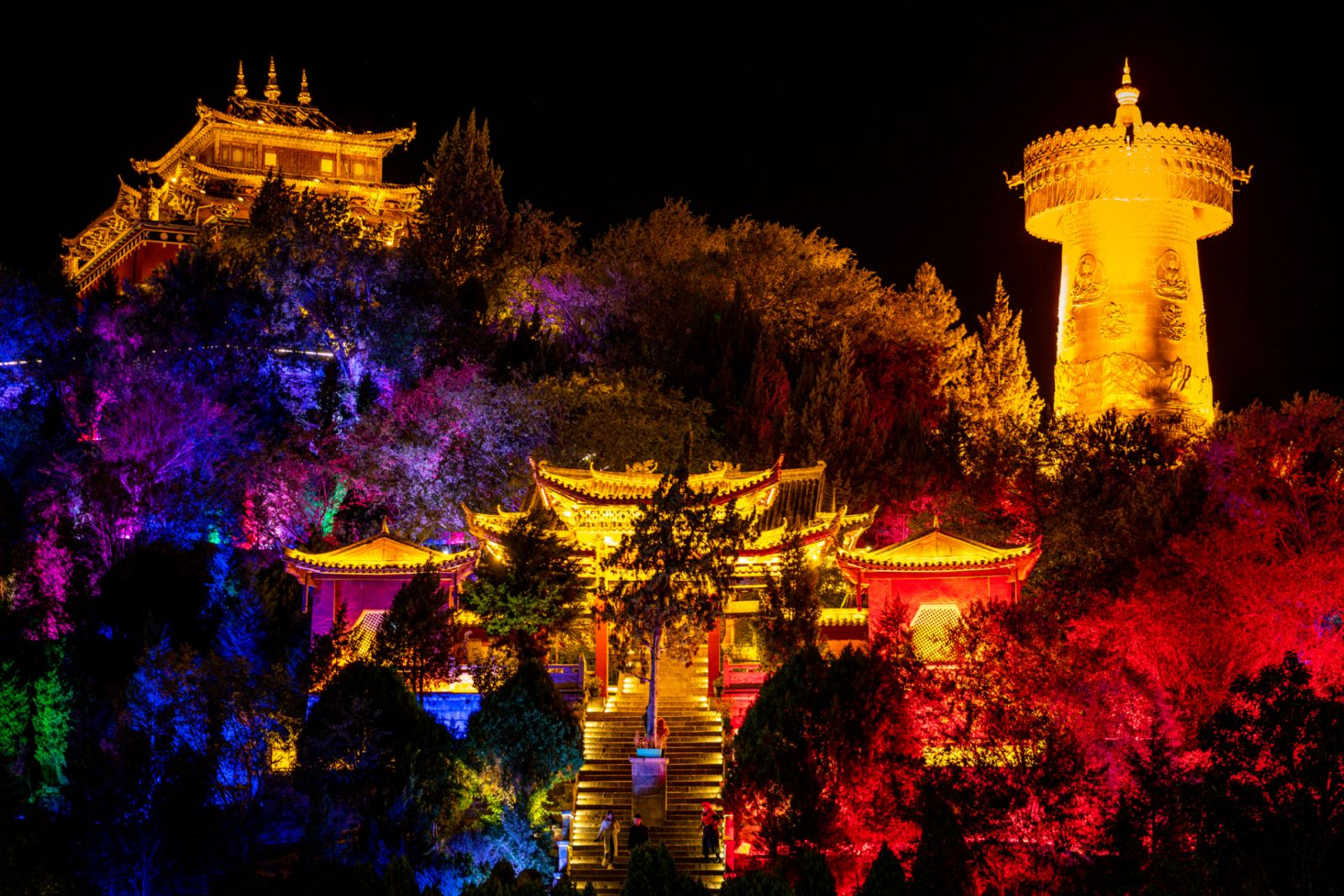 Guishan Dafo Big Buddha temple with the giant Tibetan Buddhist prayer wheel illuminated at night in Guishan park in Shangri-La Yunnan China