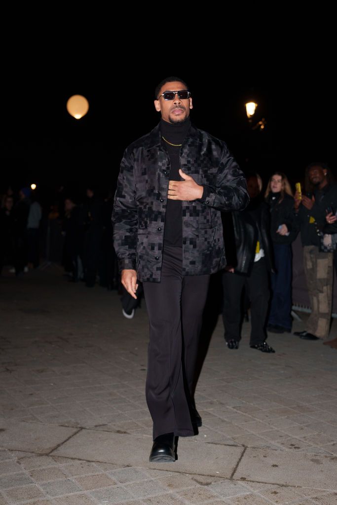 PARIS, FRANCE - JANUARY 21: Aaron Pierre wears sunglasses, a black checkered jacket, a turtleneck pullover, before the Louis Vuitton Menswear Fall-Winter 2025/2026 show as part of Paris Fashion Week on January 21, 2025 in Paris, France. (Photo by Edward Berthelot/Getty Images)
