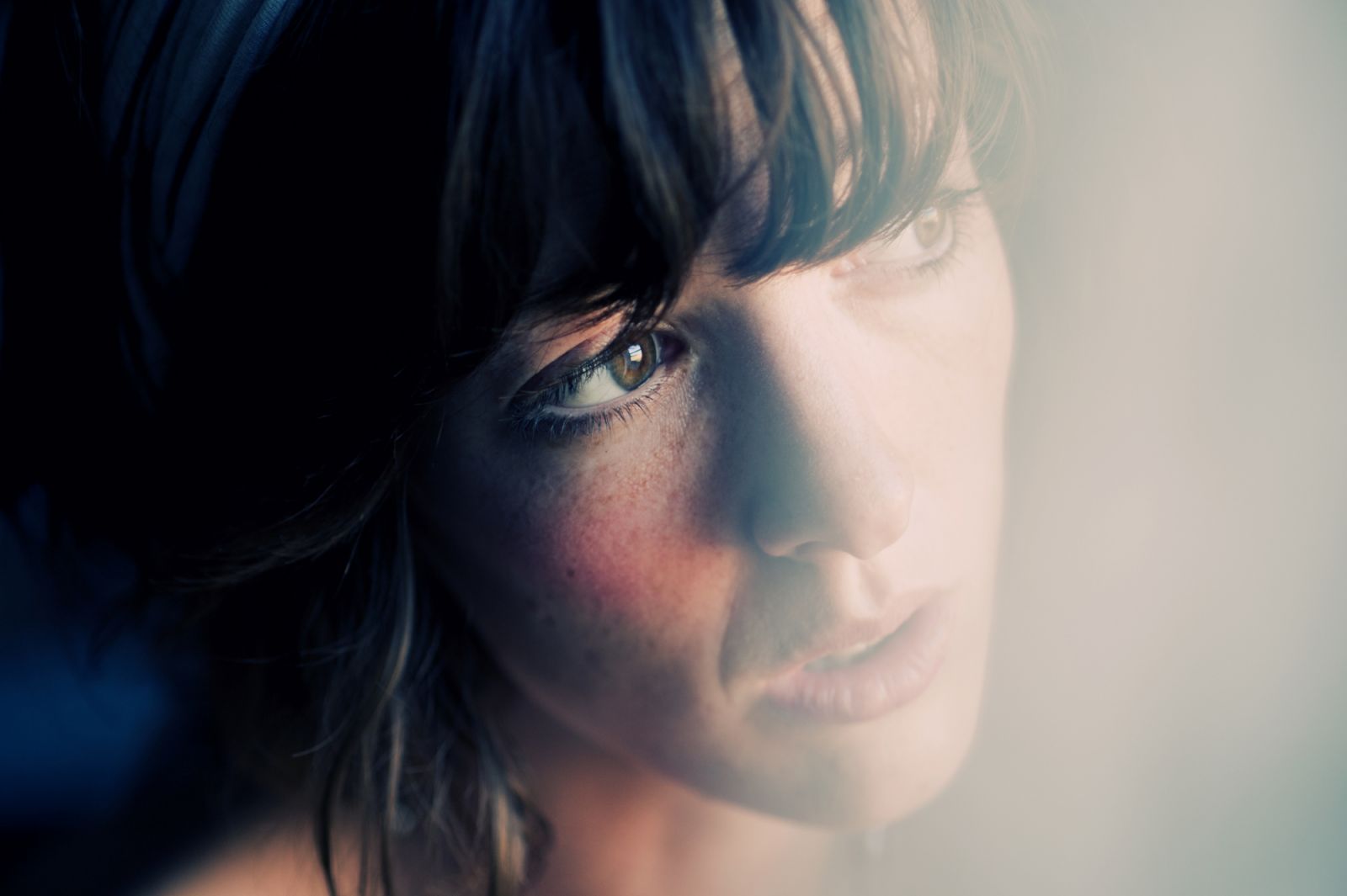 Young woman looking through window.