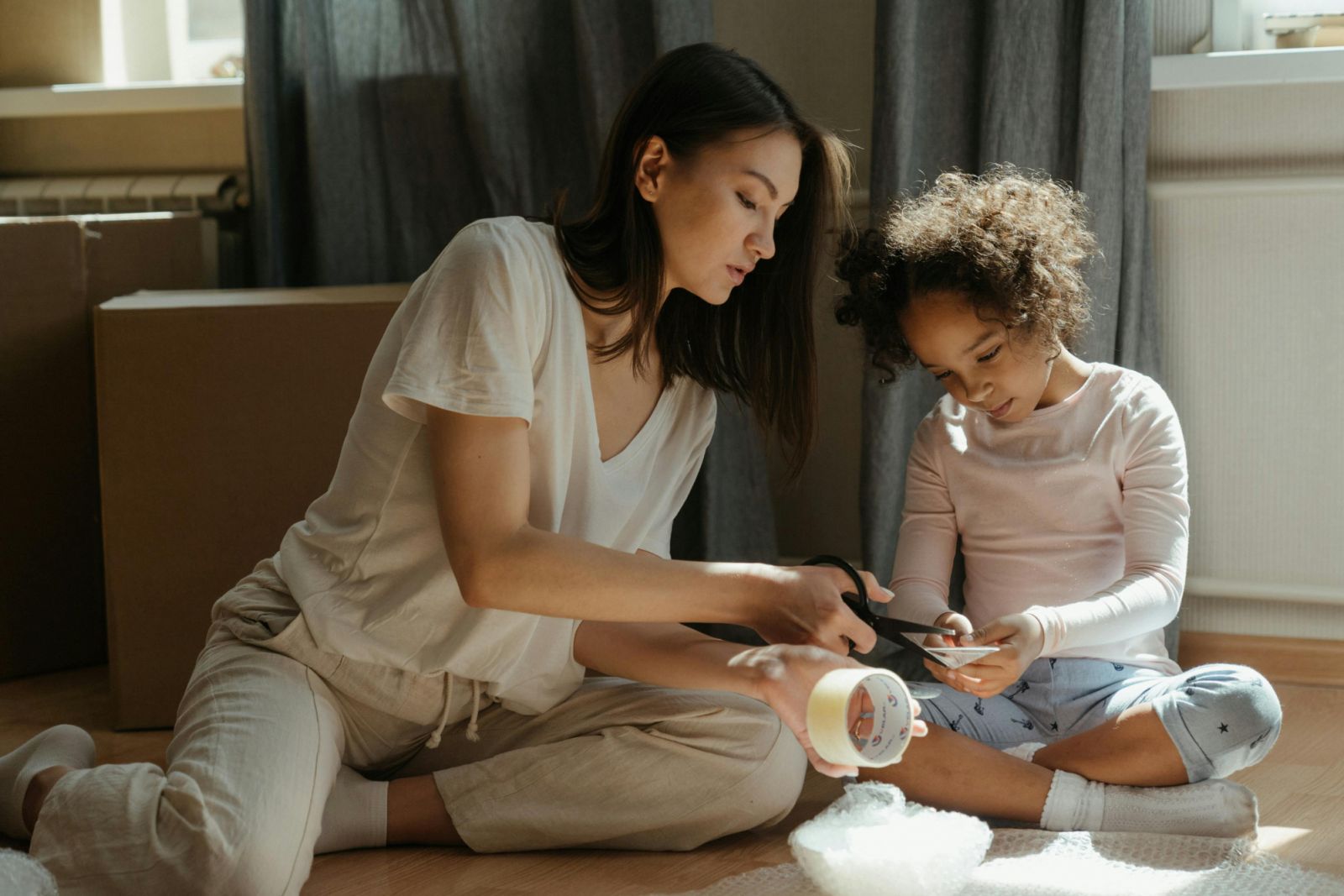 Mom and daughter cutting tape for packing