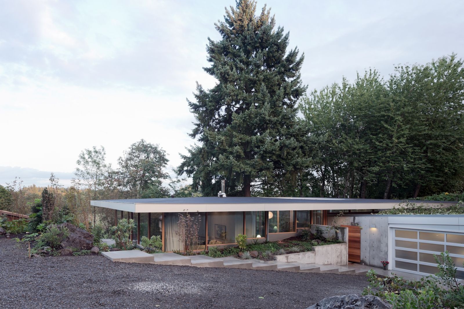 The home is sunken into the landscape, with an underground garage cut into the hillside