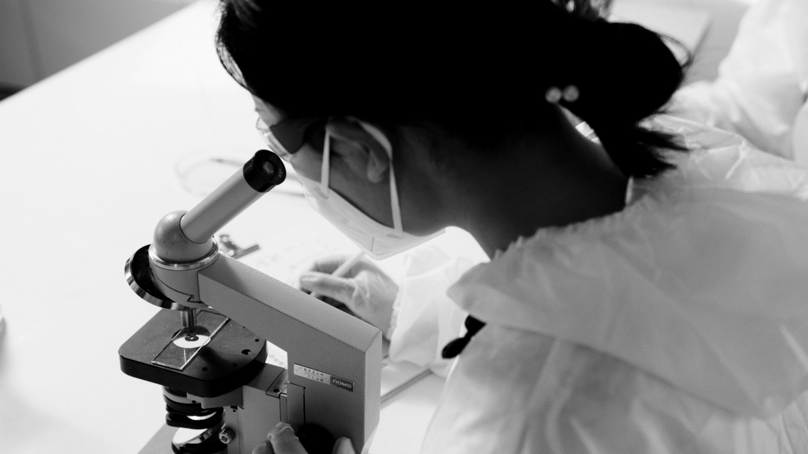 Female scientist looking at microscope