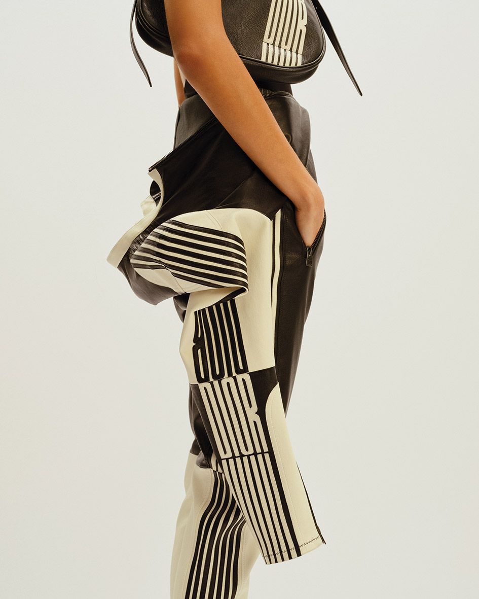 Reimagined as a linear pattern and elongated into go-faster stripes, the foulard motif appears on leather trousers, biker jackets, and over-the-knee leather flip-flops