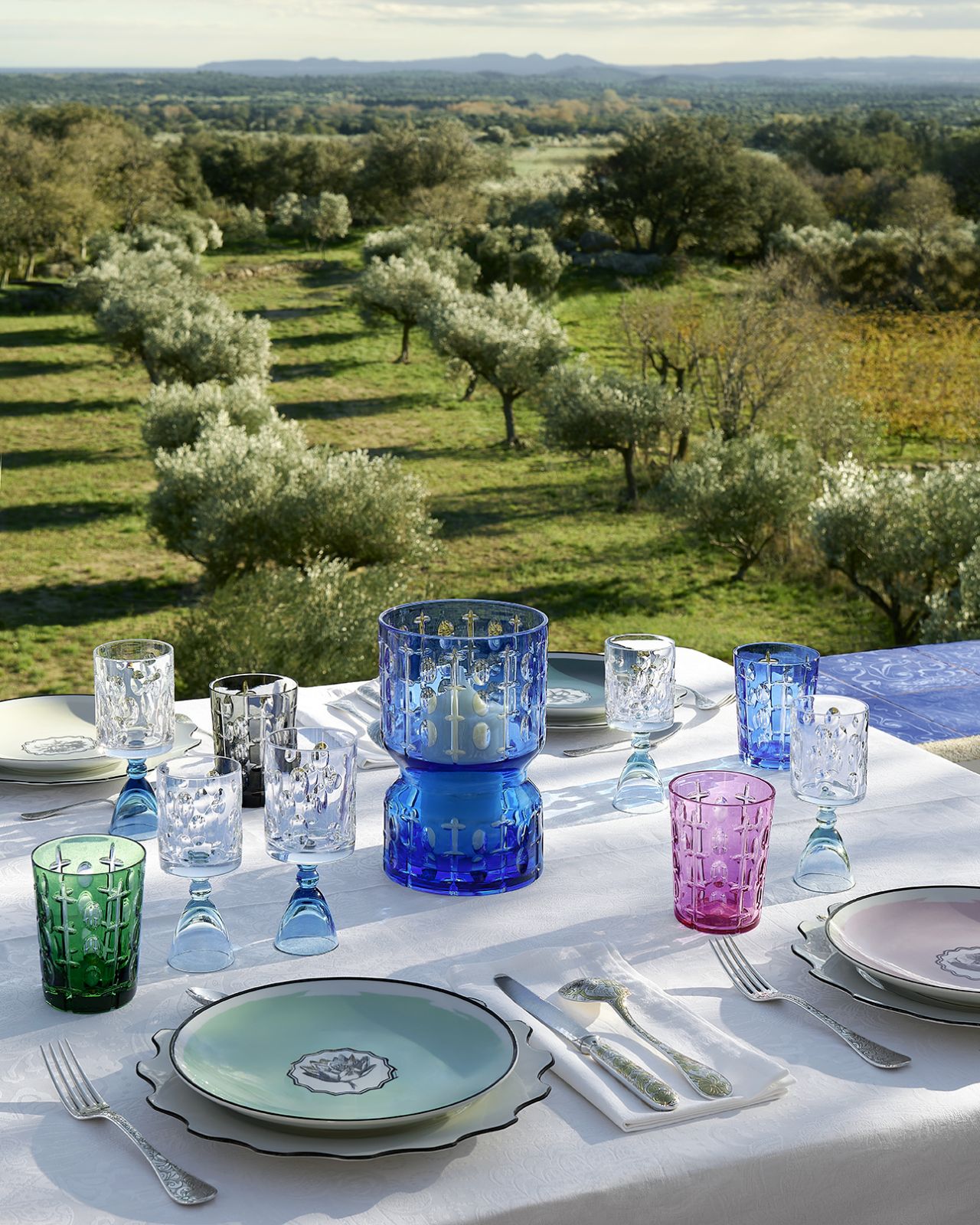 The Rêve de Cristal collection showcases jewel-toned glasses alongside the house's signature porcelain plates in mint and pastel hues