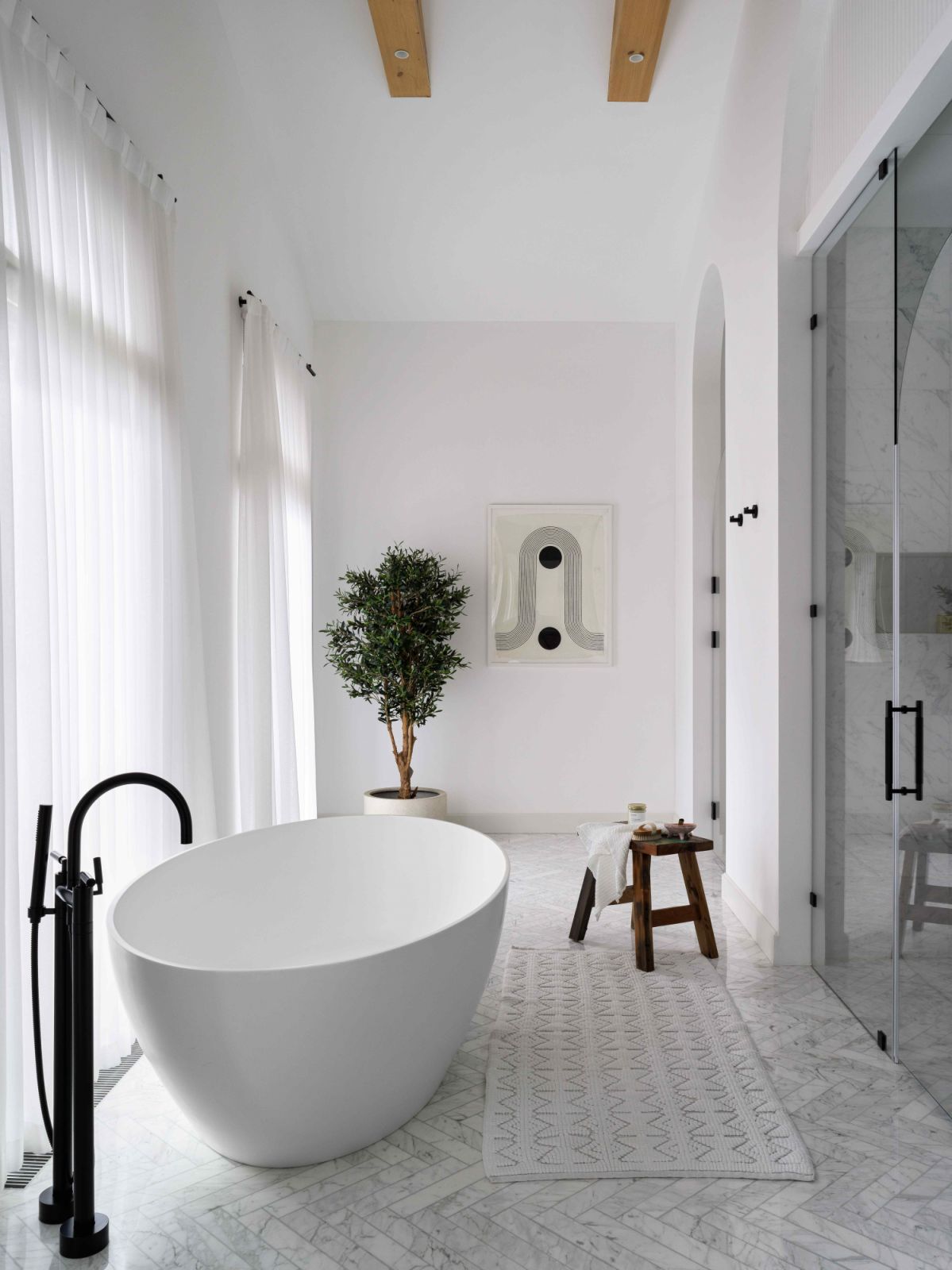The high-ceilinged en-suite with herringbone marble flooring