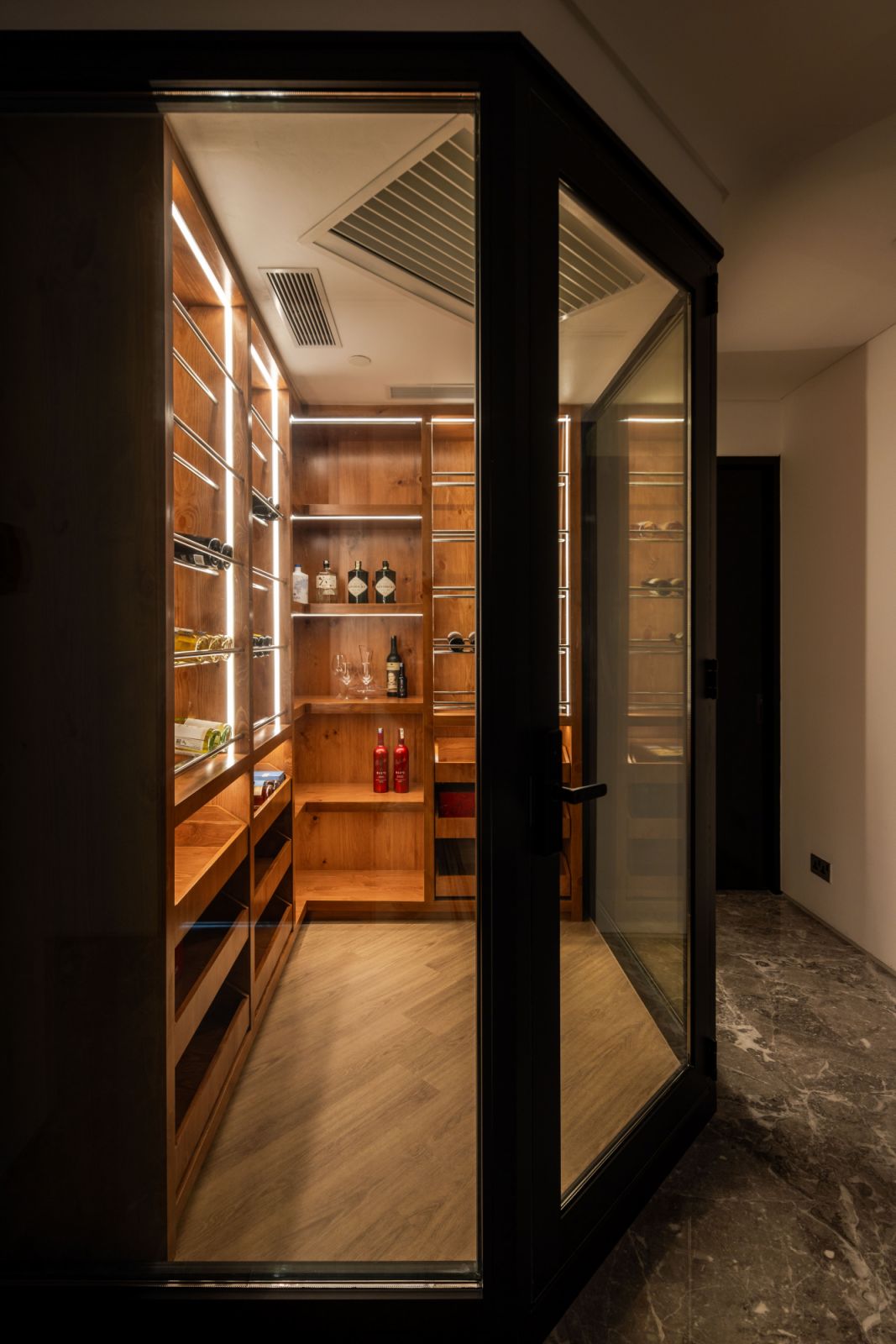 Custom-built climate-controlled storage marries form and function in this dedicated wine and spirit room