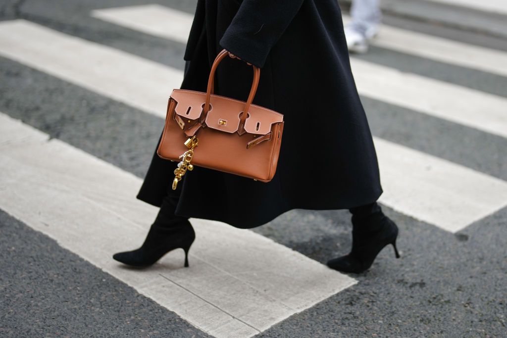 PARIS, FRANCE - JANUARY 30: A guest wears black pointed toe heels boots, a shiny dark brown Hermes leather bag, outside Miss Sohee, during the Haute Couture Spring/Summer 2025 on January 30, 2025 in Paris, France. (Photo by Edward Berthelot/Getty Images)