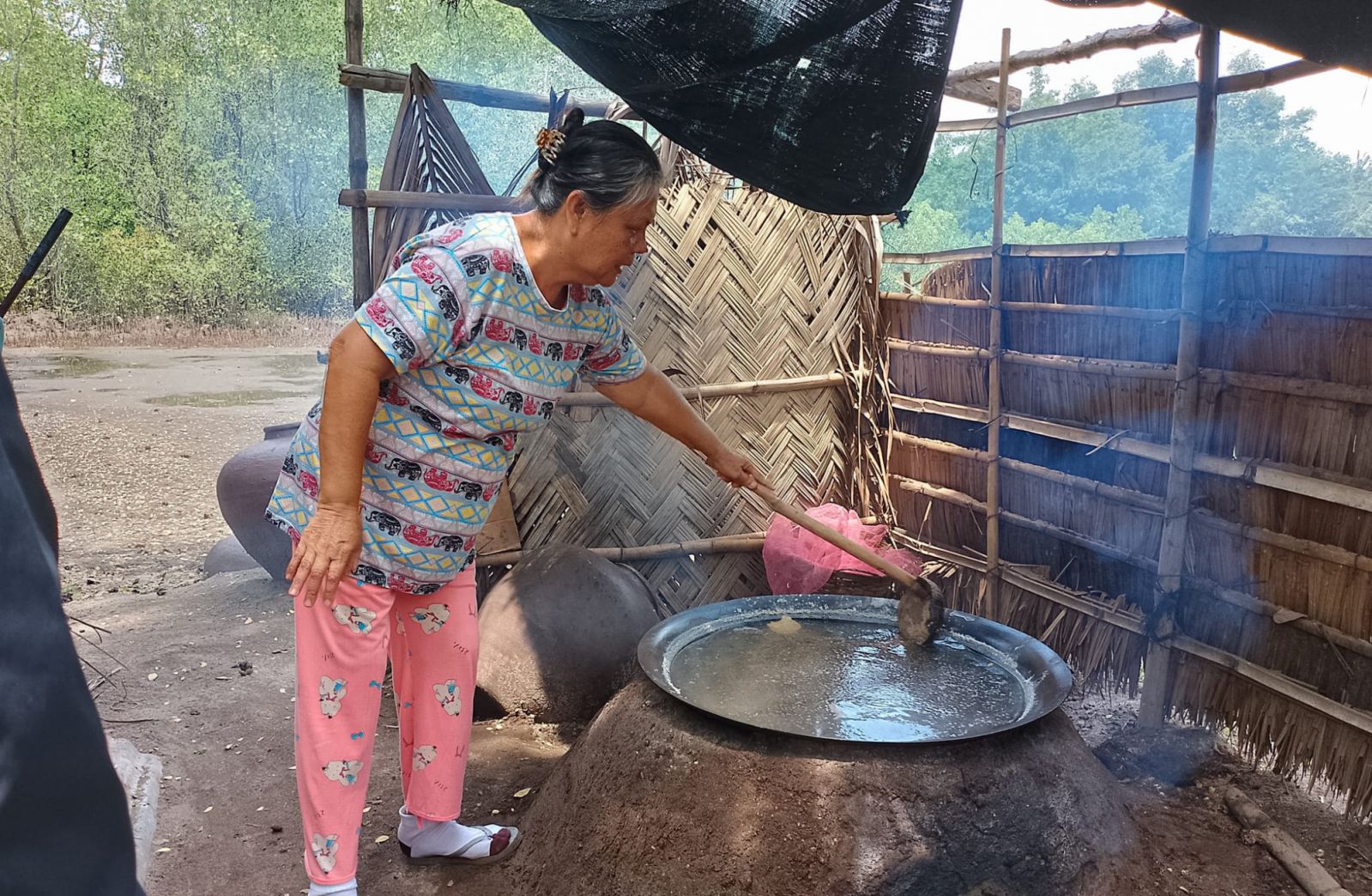 A Filipina farmer cooking artisanal sea salt in an outdoor oven