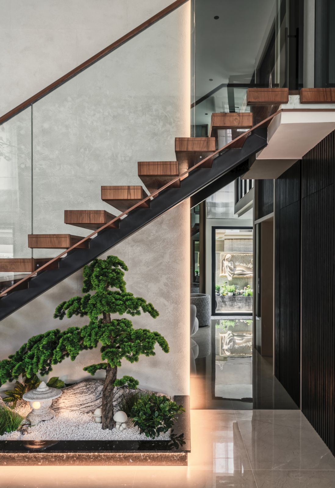 An indoor zen garden tucked under the floating staircase brings the outdoors in