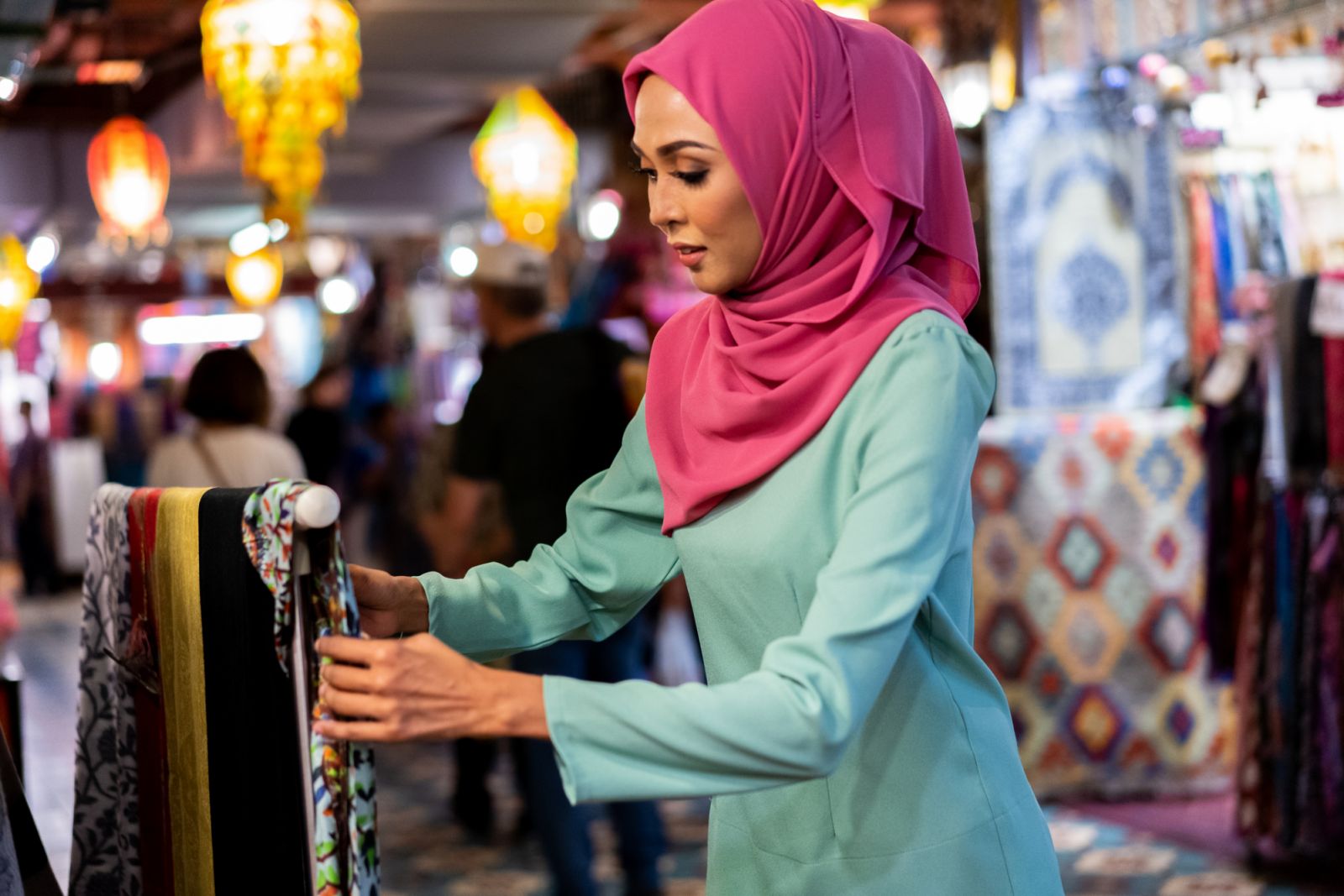 Attractive Malay female shop owner preparing her ware for Ramadan at market bazaar.