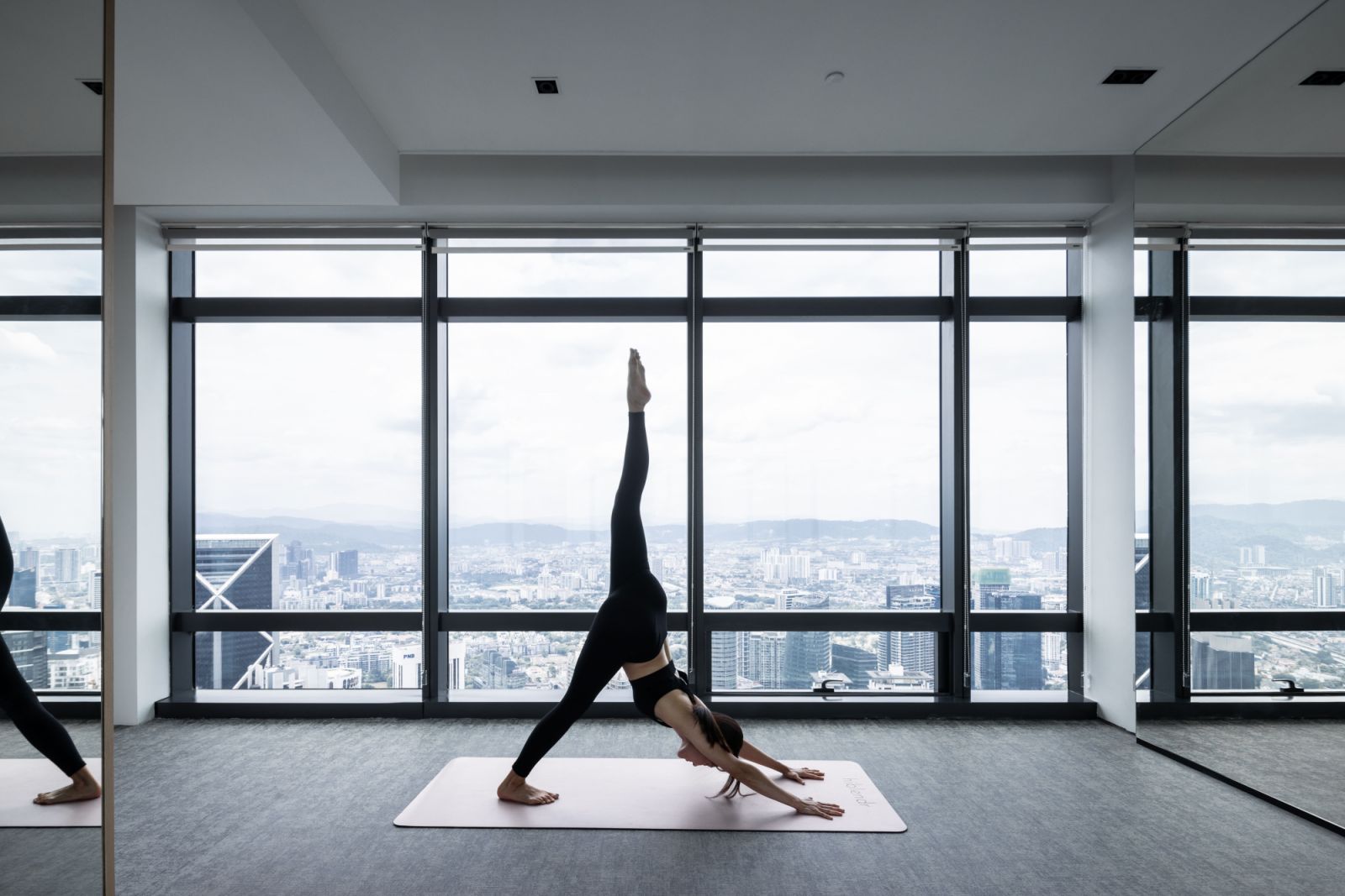 Heavy-duty carpet tiles and stainless steel equipment racks create a modern workout space