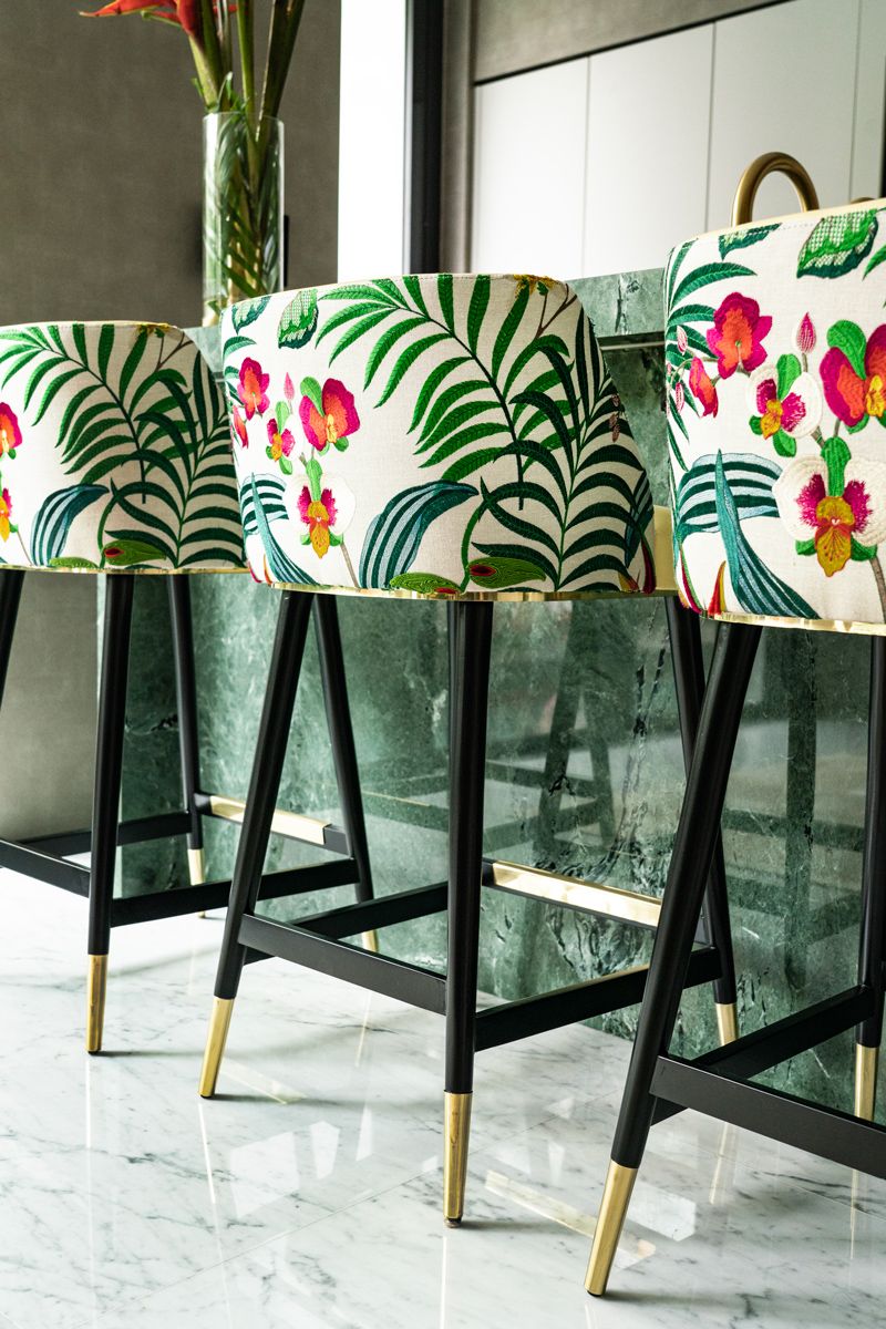 The floral upholstery of the bar chairs lends a biophilic touch