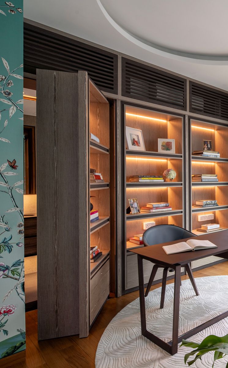 The door to the bathroom is seamlessly integrated into the bookcase wall in the wife’s study