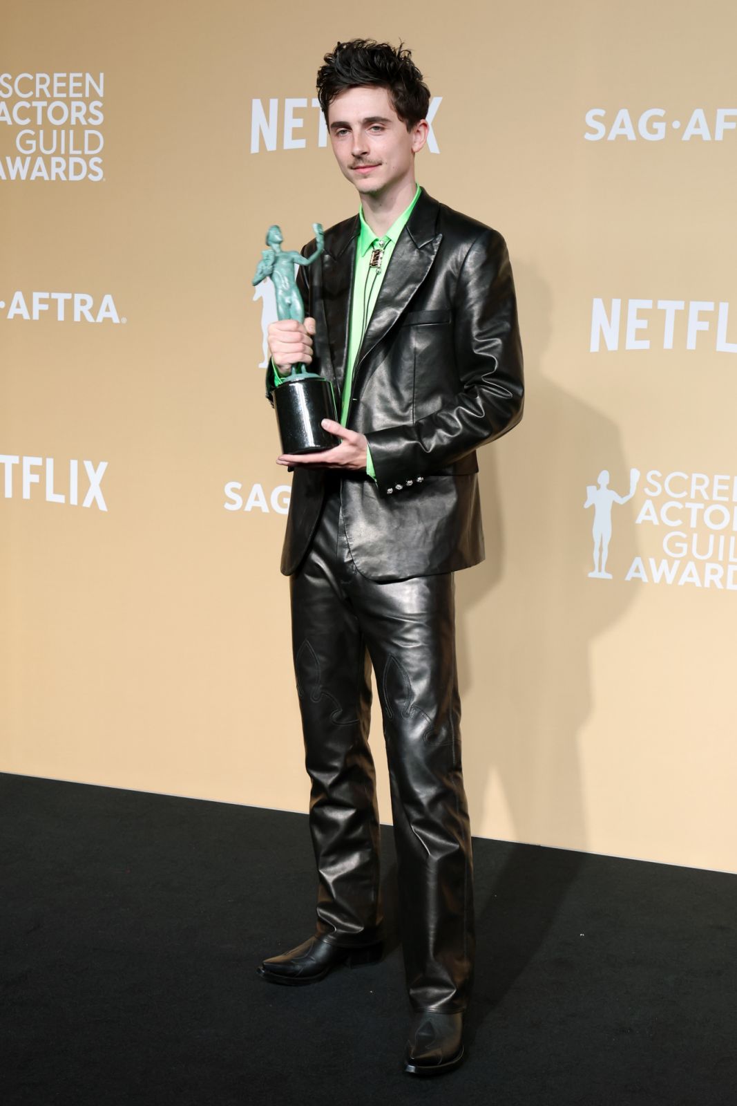 Timothée Chalamet ในชุดสูทหนังพร้อมเสื้อเชิ้ตสีเขียว (ภาพ: Amy Sussman / Getty Images)