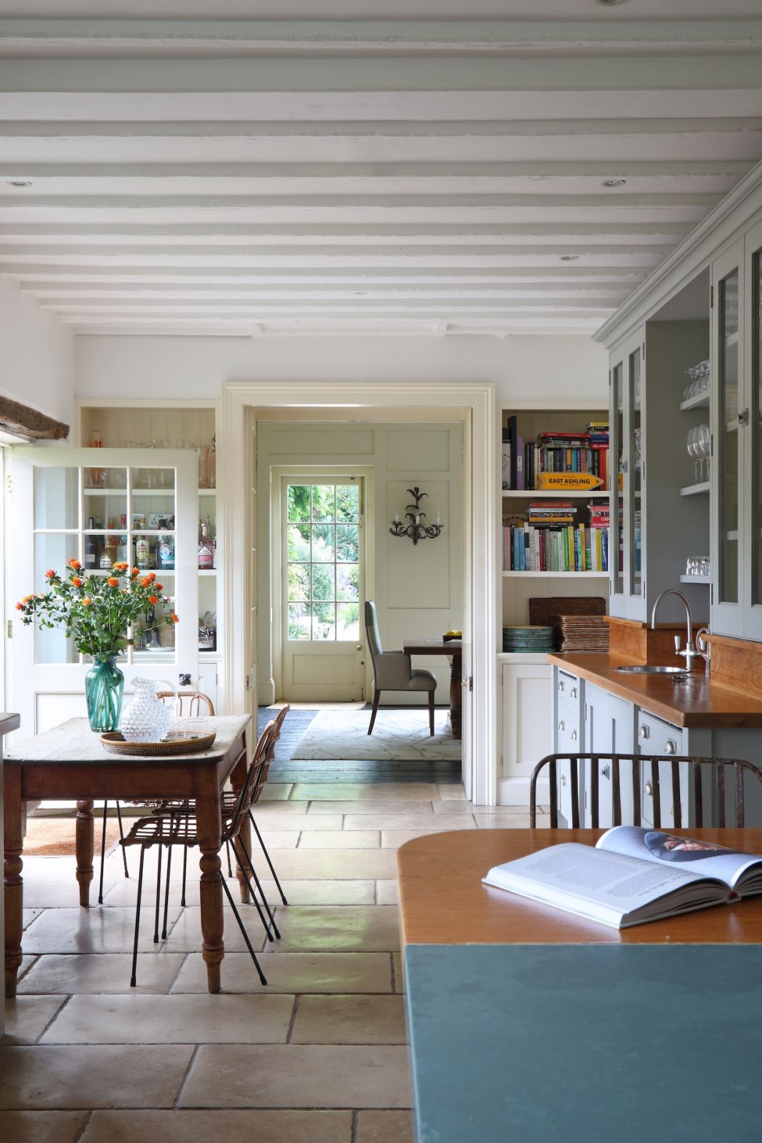 The kitchen is rooted in elements of Shaker design with the centre island to the mahogany countertops leading to the informal dining room, with high-backed faux leather dining chairs around the stunning, oak-inlaid table
