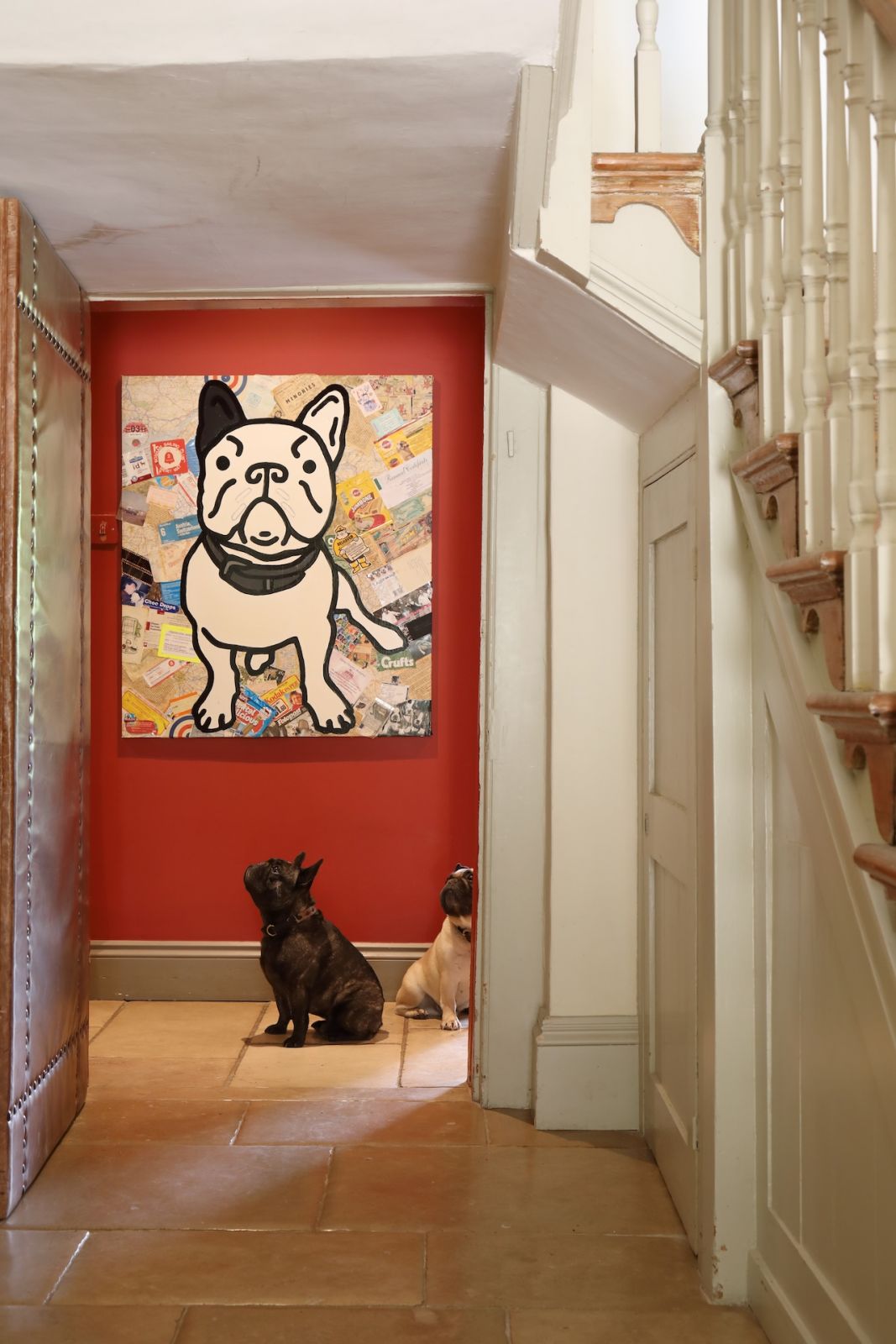 The hallway leading off an original Georgian staircase, with a glimpse of the family's eclectic art collection