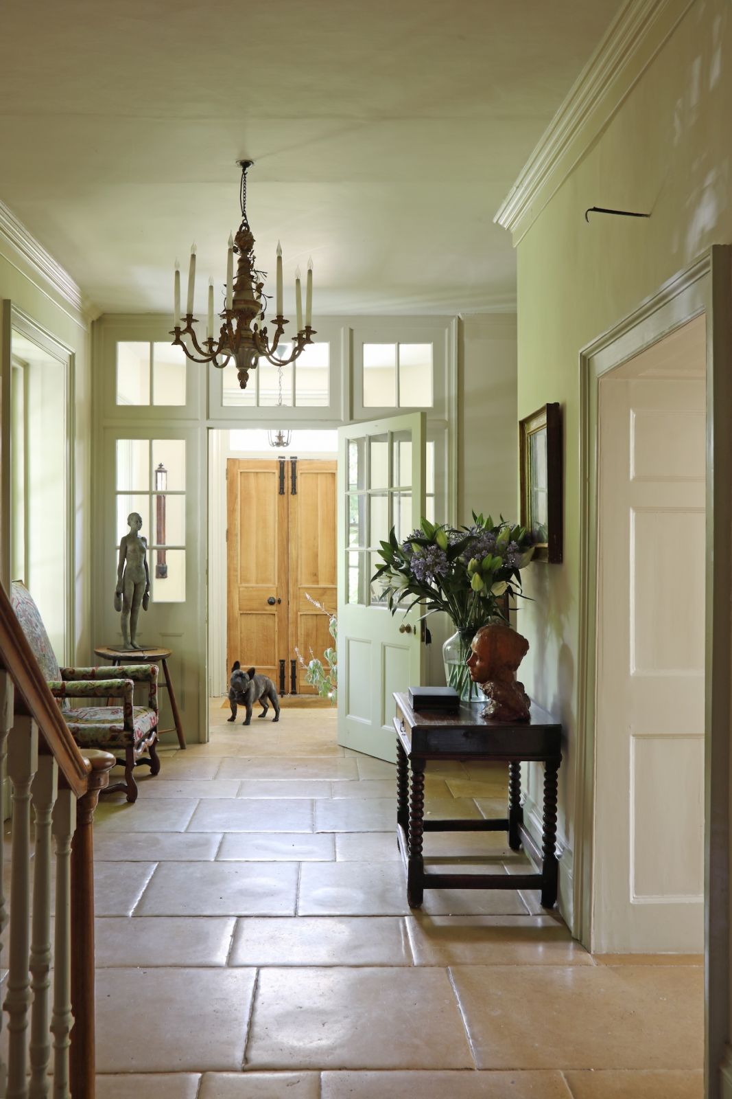 The entryway of a Sussex, England home with a tumbled limestone floor
