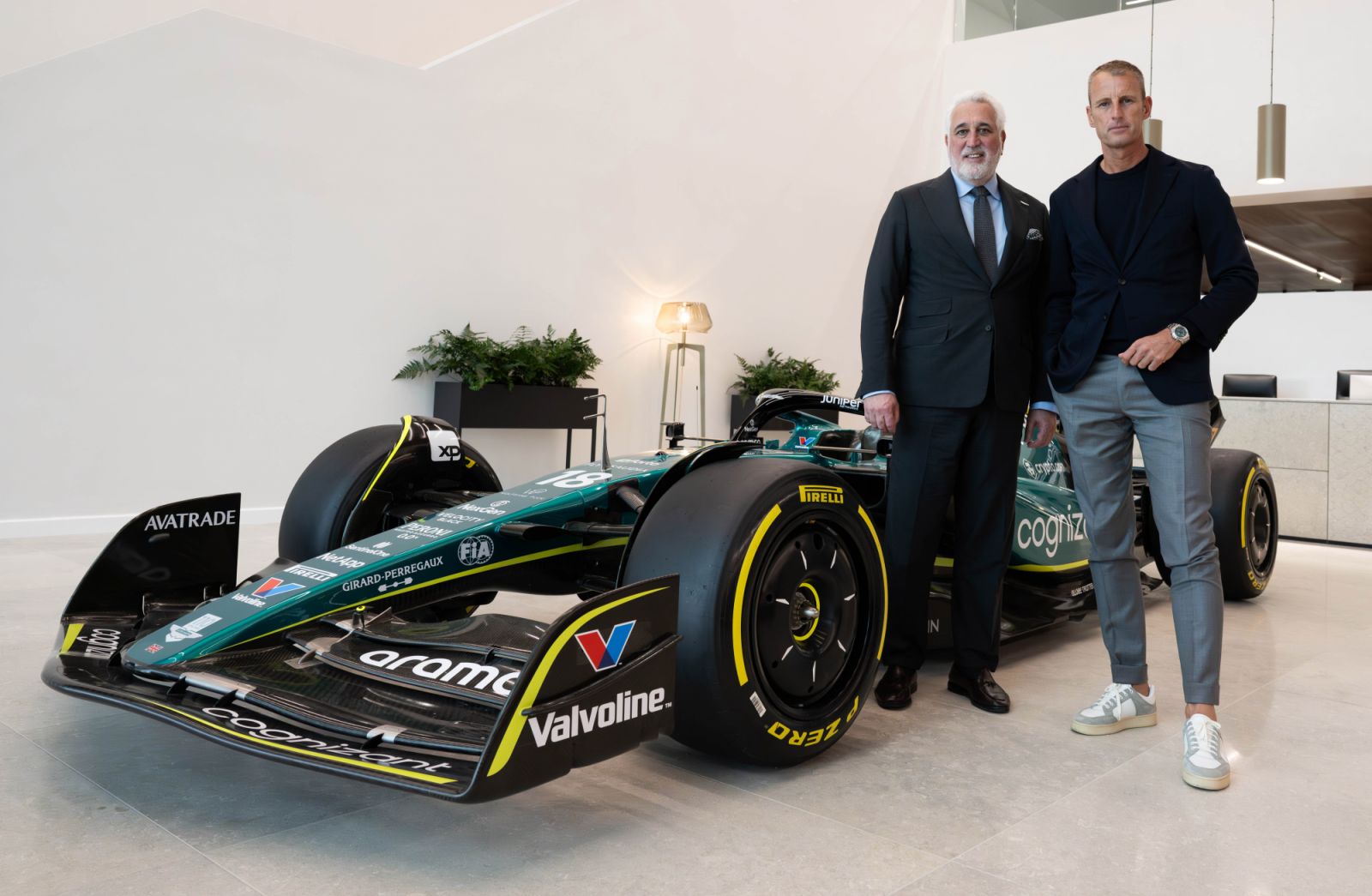 Aston Martin’s executive chairman Lawrence Stroll and Girard-Perregaux’s CEO Patrick Pruniaux posing next to the Aston Martin Aramco Formula One Team car in 2024