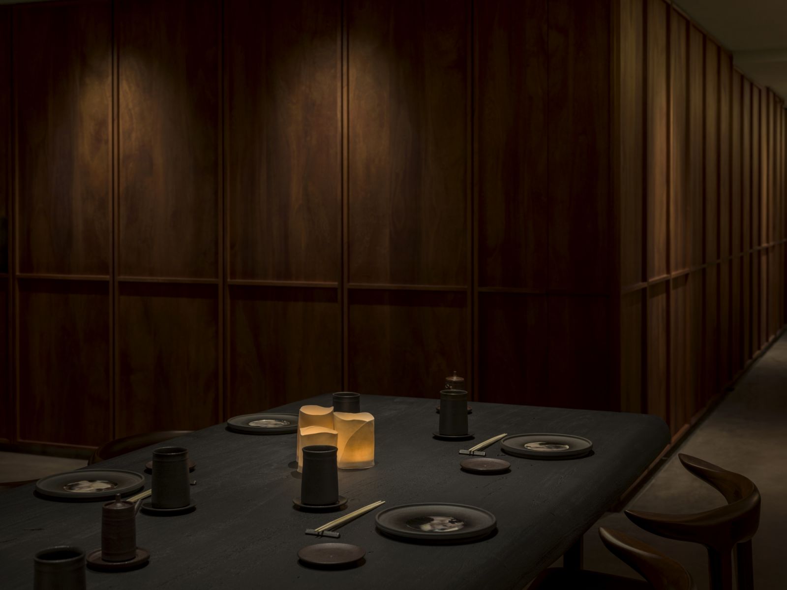 Sushi Park’s atmosphere is intimate and moody, accented by dark wood, waxed concrete, steel, and subdued lantern lighting (Photo: Saint Laurent)