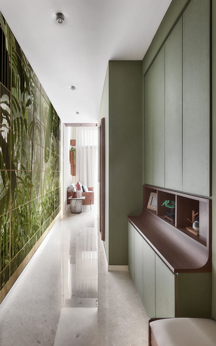 Tropical-themed wallpaper and sage-green tones infuse this corridor with a biophilic atmosphere