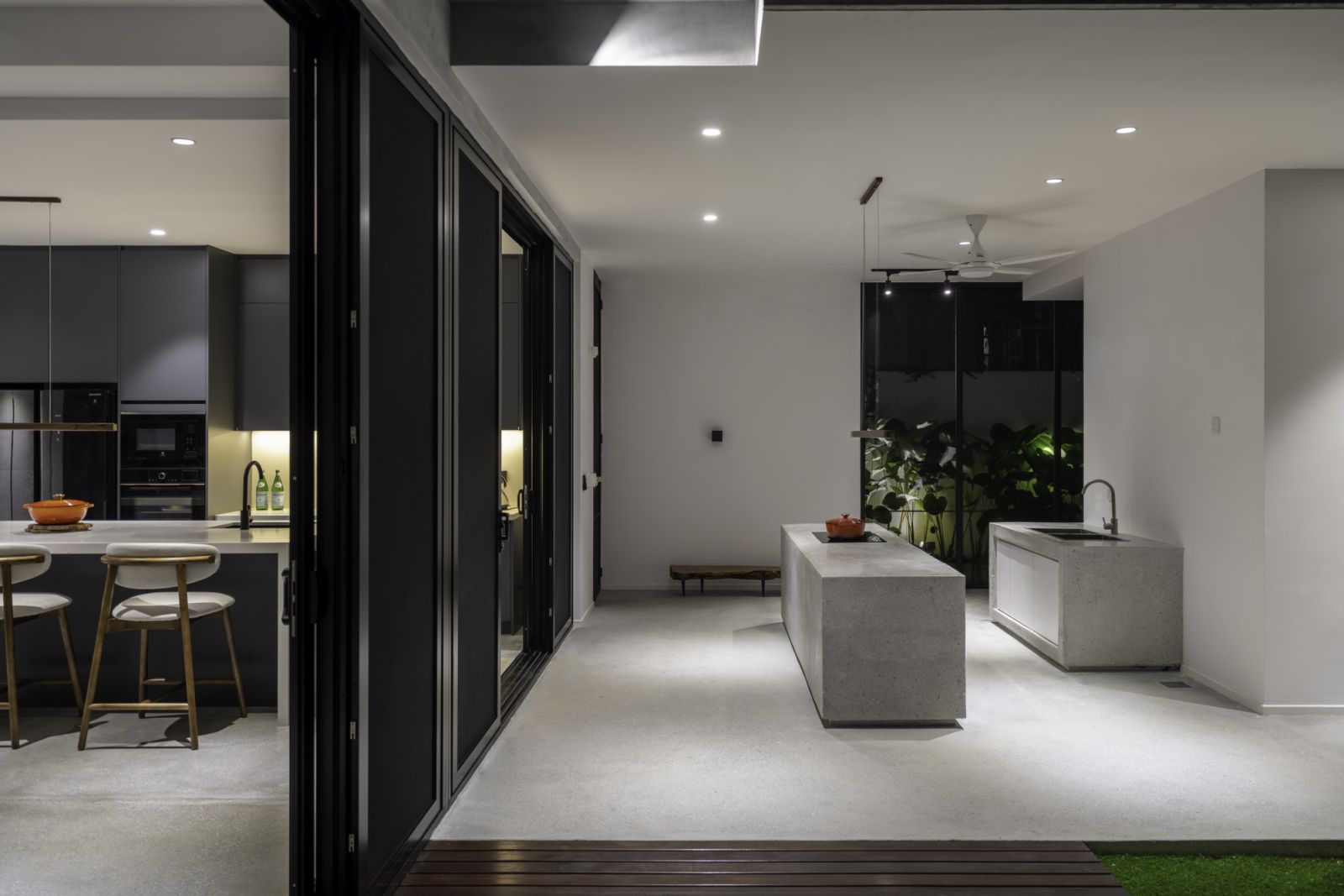 Minimalist concrete islands provide ample work surfaces, while the monochromatic color palette creates a calm atmosphere