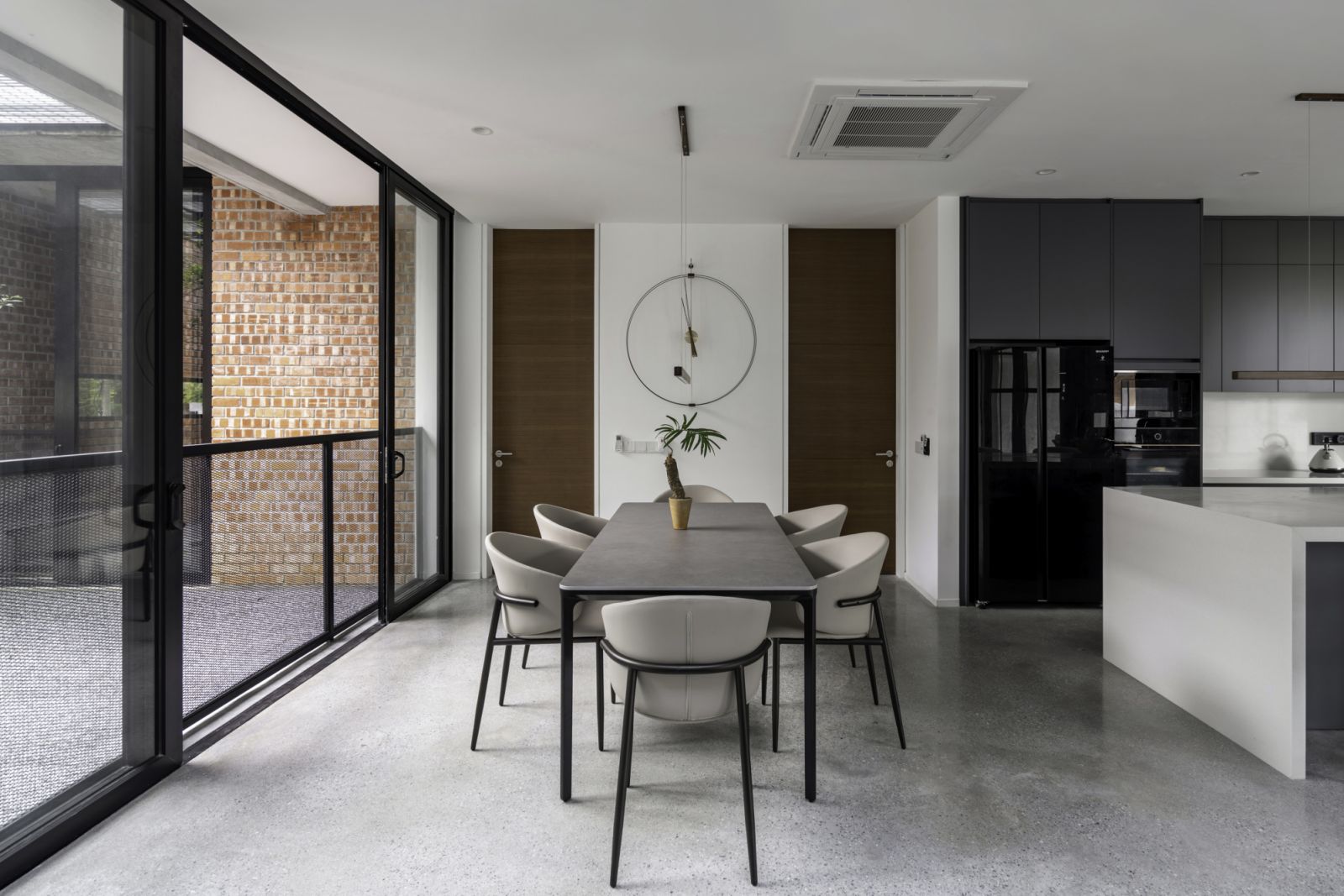 The dining area showcases the home’s refined material palette and connection to outdoors