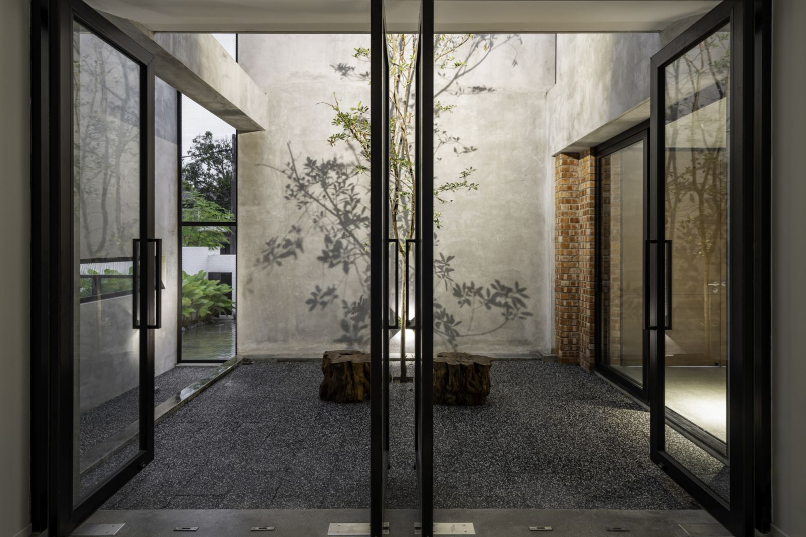 A contemplative inner courtyard underlines the emphasis on natural elements and serene transitional spaces