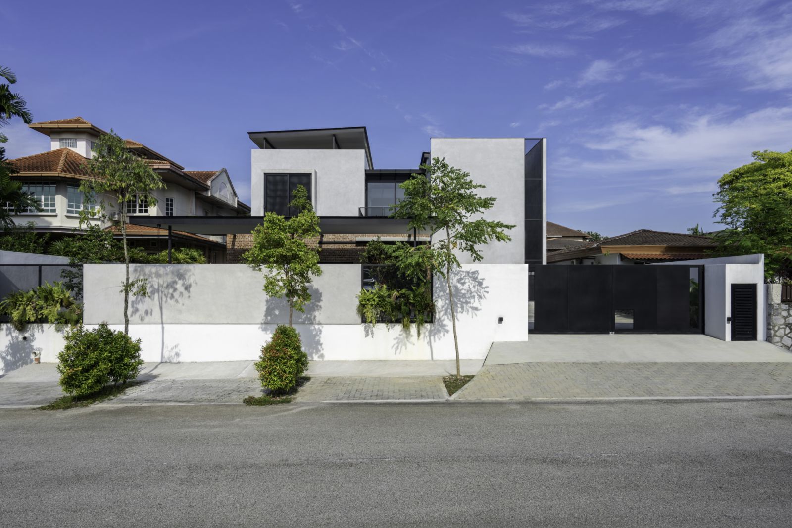 The street façade presents a confident contemporary statement among the more traditional homes of Petaling Jaya