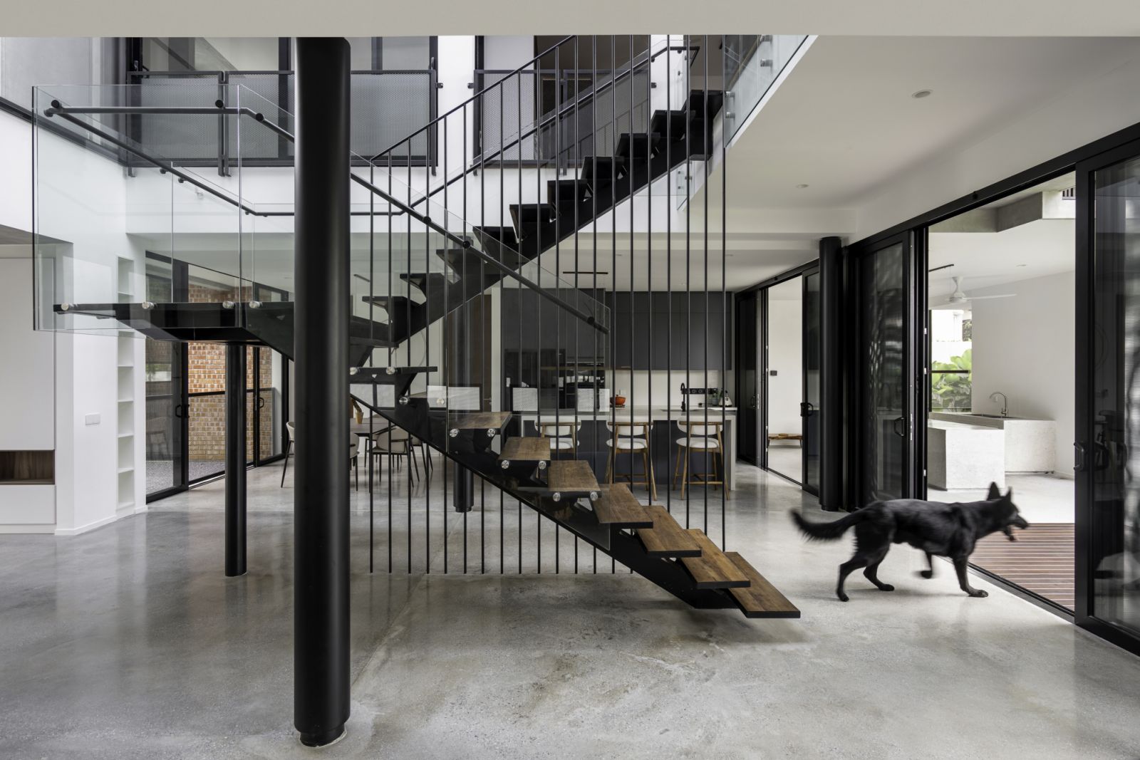 Natural wood elements in the stair treads and furniture warm the monochromatic palette