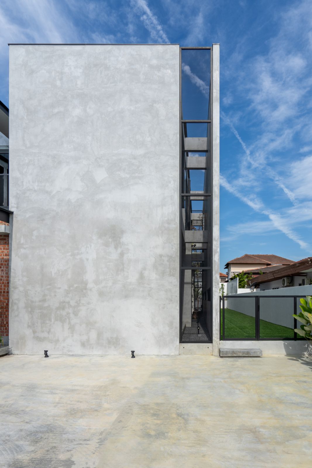 A striking architectural detail featuring a towering concrete wall with a narrow vertical cutout running its entire height