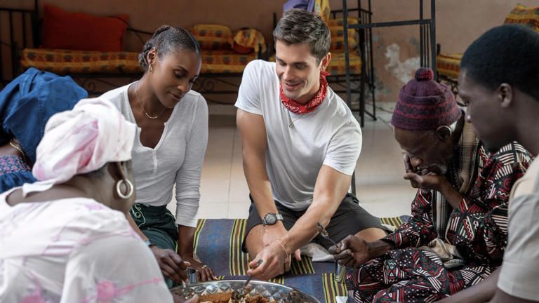 Issa Rae and Antoni Porowski enjoying a traditional meal in Senegal. (Image: National Geographic)