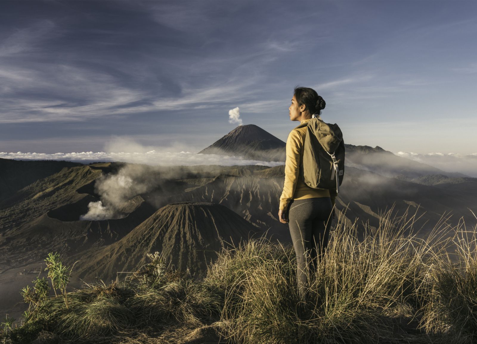asia, indonesia, java, asian woman standing infront of mount bromo and mount semeru, admiring the view at sunrise