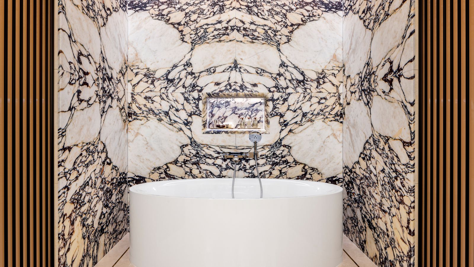 Bookmatched marble slabs lend a spectacular graphic touch to this bathroom