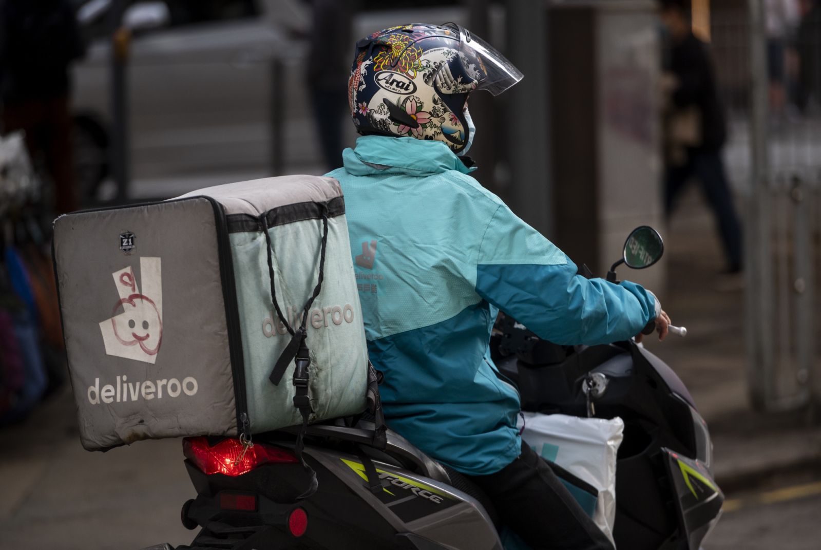 HONG KONG - DECEMBER 30: A delivery worker from the delivery take out food company Deliveroo is seen riding on a motorbike in Hong Kong on December 30, 2021. (Photo by Miguel Candela/Anadolu Agency via Getty Images)