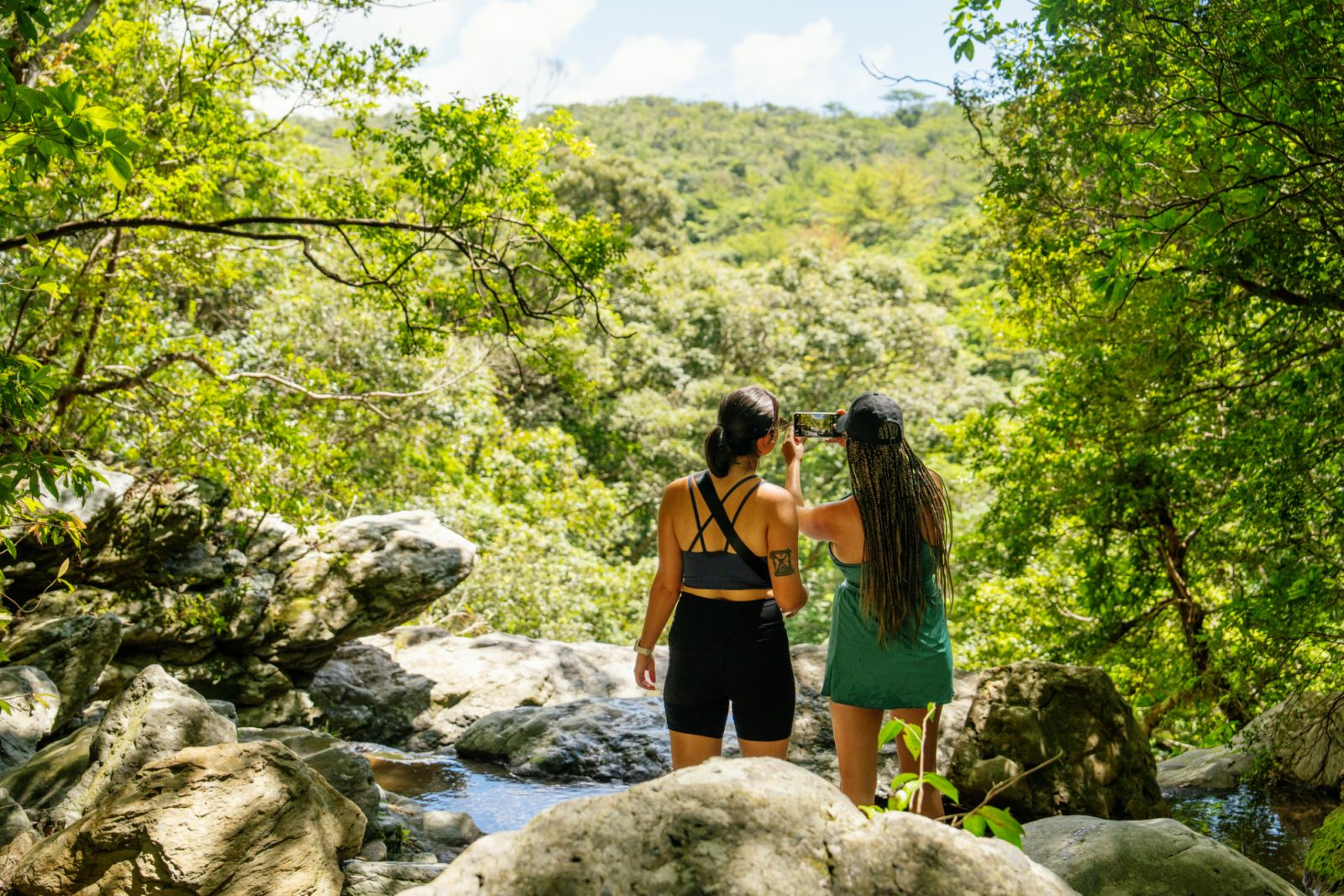 Two women taking a picture during a hike in the jungle while on a weekend adventure