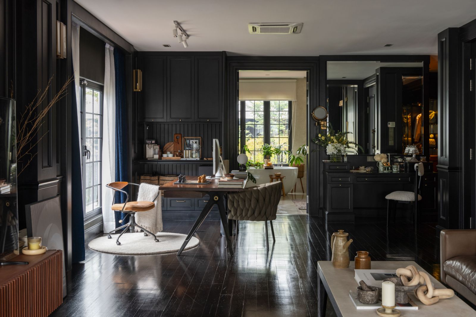 Bold design choices define the master bedroom with double-ceiling height black wood panelling