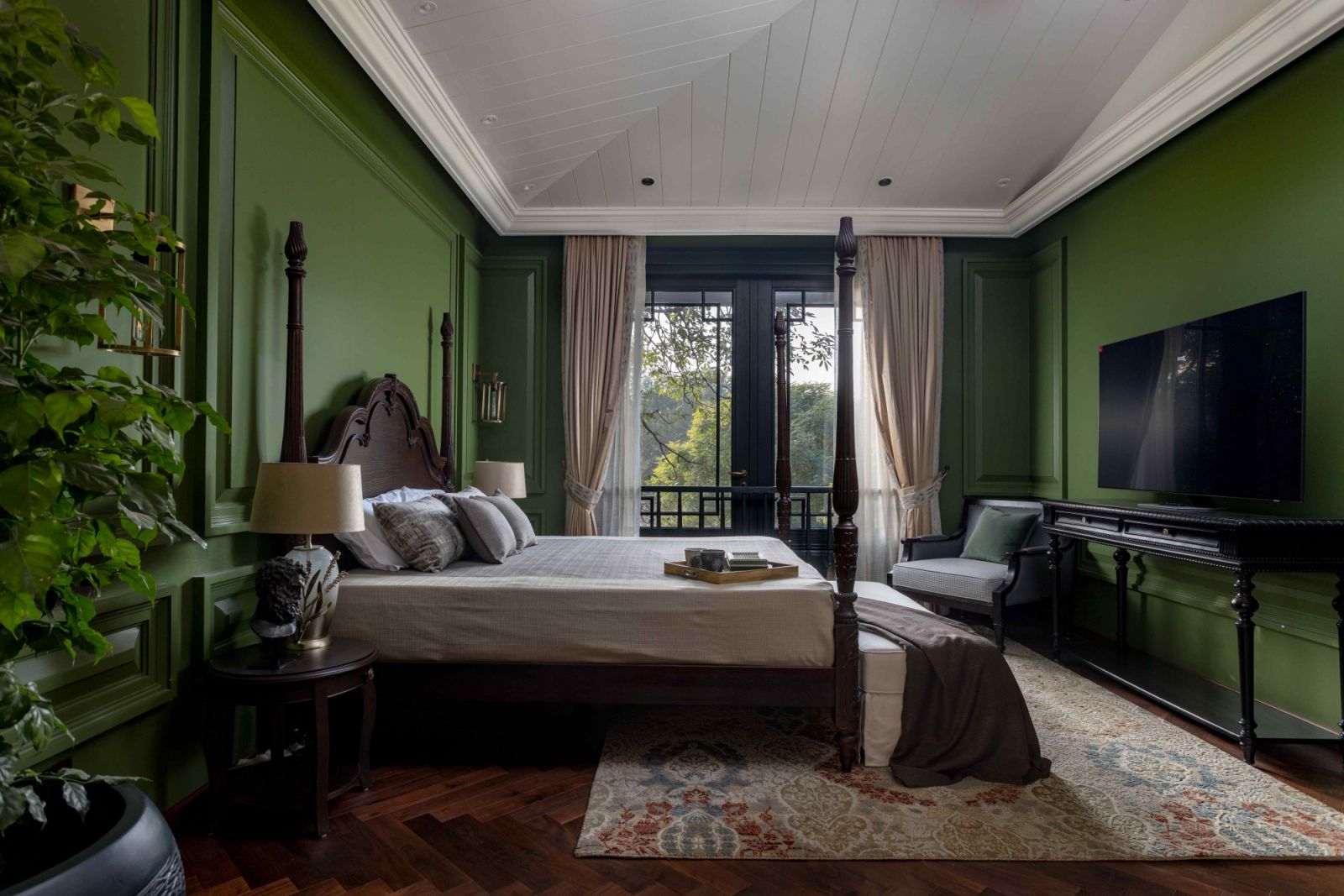Deep green panelled walls echo the lush landscape outside