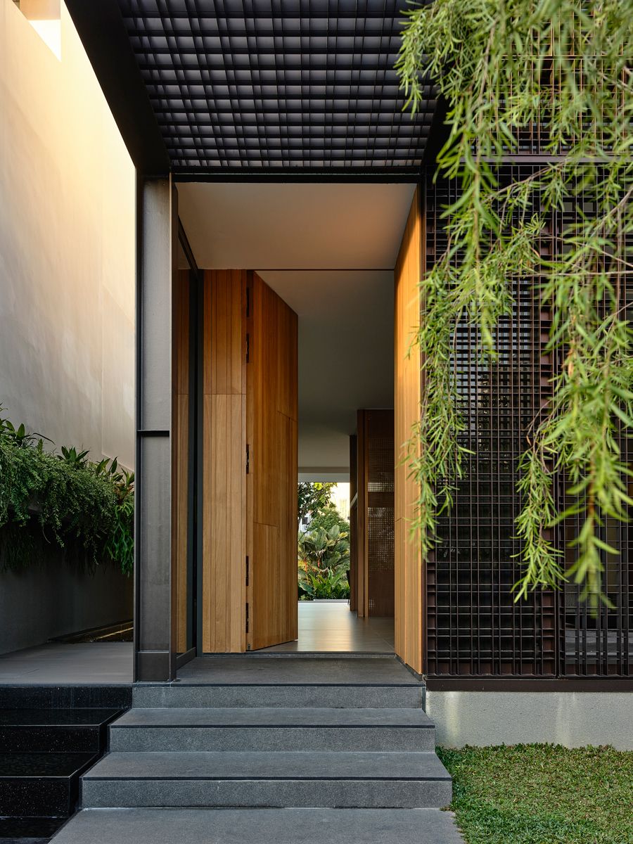 The entrance is softened by greenery and natural materials