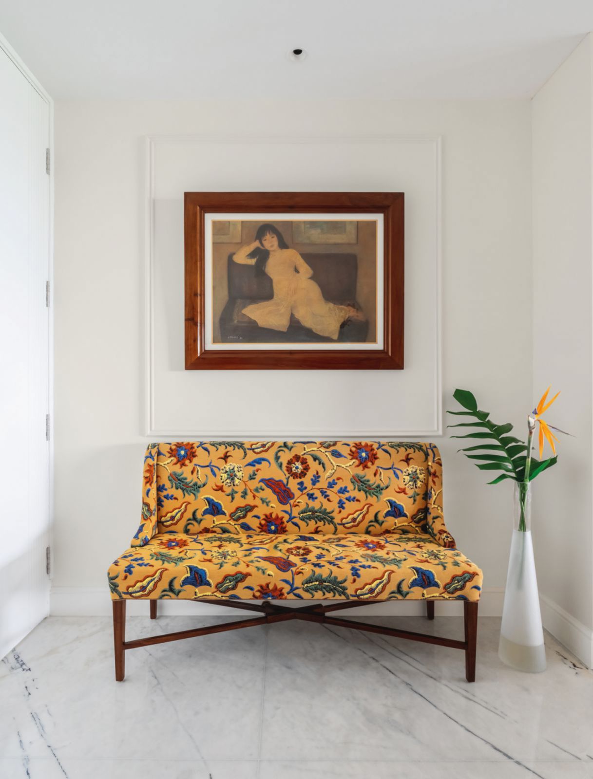 A painting by Vietnamese artist Linh Chi hangs above a paisley-patterned sofa in the entryway