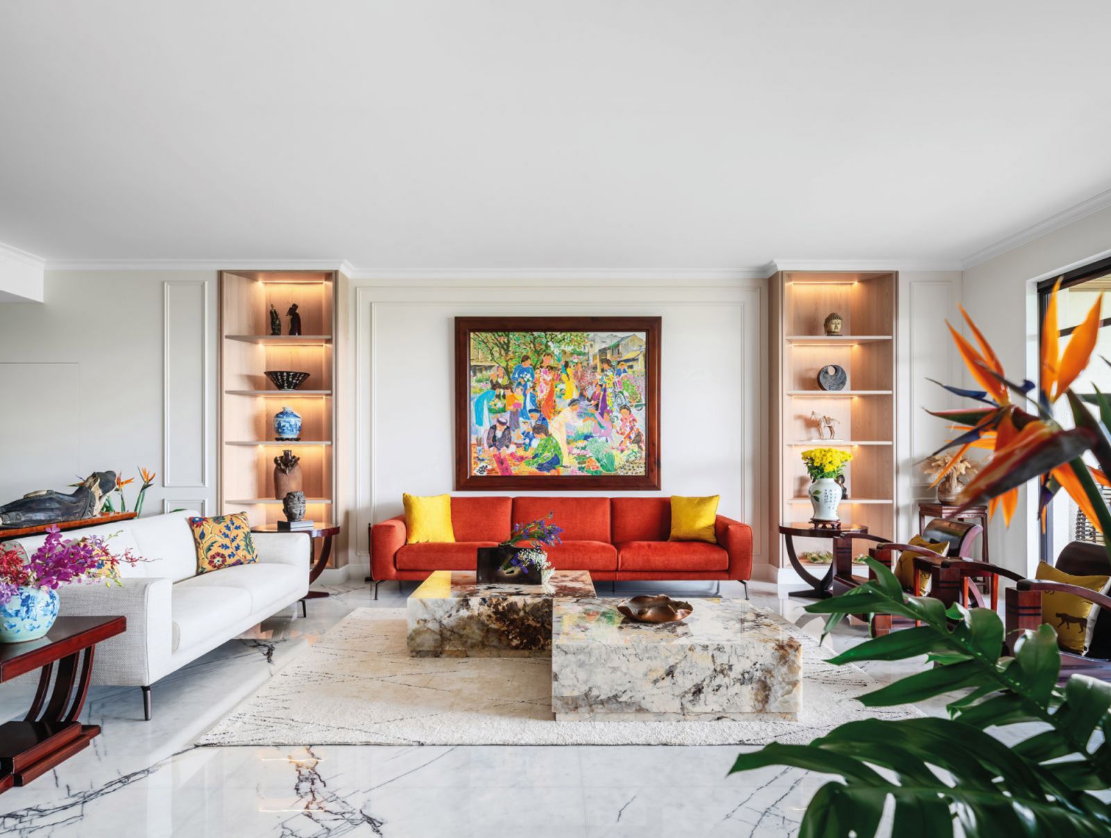 A pair of hefty Patagonia granite coffee tables grounds the look of the handsome living room of The Arcadia, by Summerhaus D’zign, which also features a painting by Tran Nguyen Dun and book-matched New York marble flooring