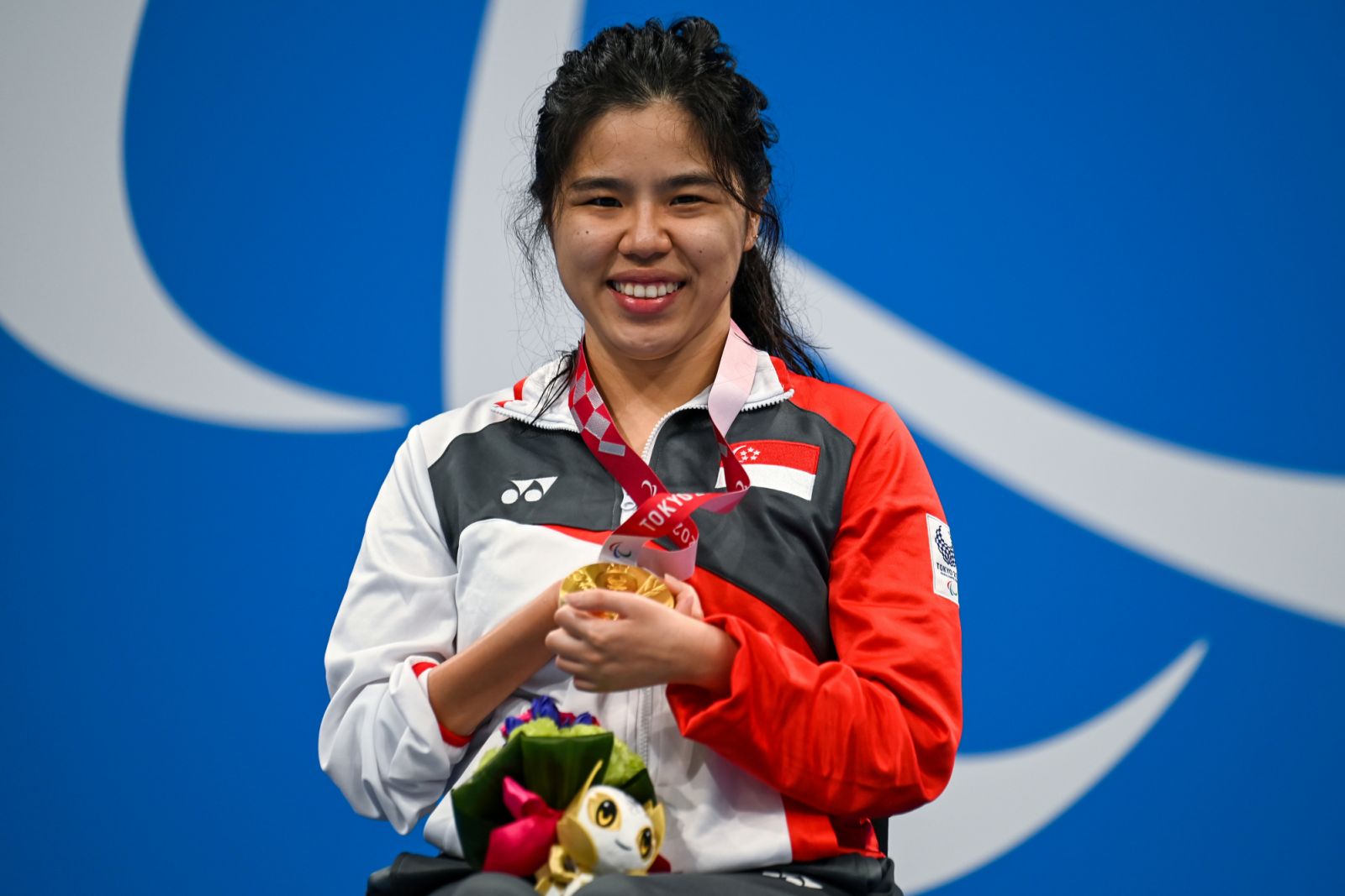 Gold medallist Singapore's Yip Pin Xiu celebrates on the podium at the end of the women's 50m backstroke S2 swimming event during the Tokyo 2020 Paralympic Games at the Aquatics Centre in Tokyo on September 2, 2021. (Photo by CHARLY TRIBALLEAU / AFP)