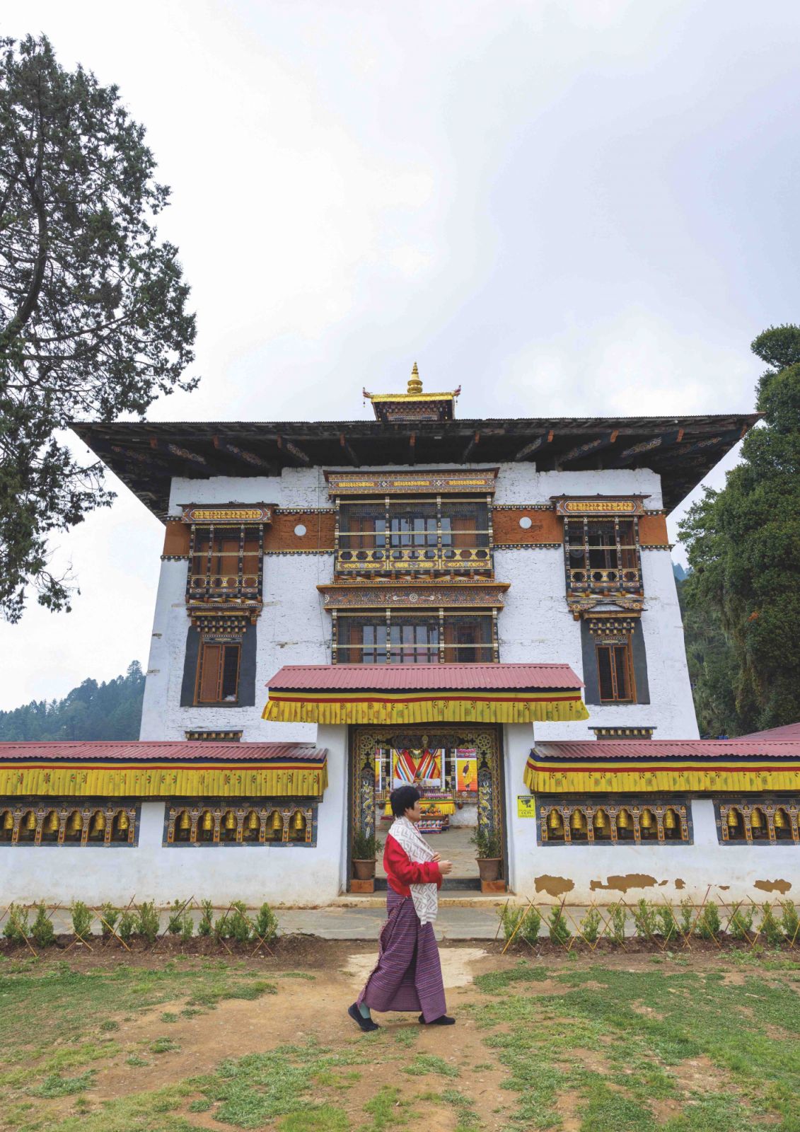 A Bhutanese woman in traditional dress in front of Tashigang Gonpa at the Punakha dzongkhag fortified monastery in Bhutan. The country has a distinct culture and with a population of just 750,000 is particularly vulnerable to mass tourism (Photo: Getty Images)